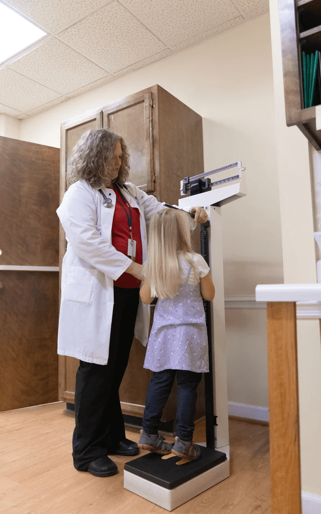 Doctor measuring a child's weight and height.