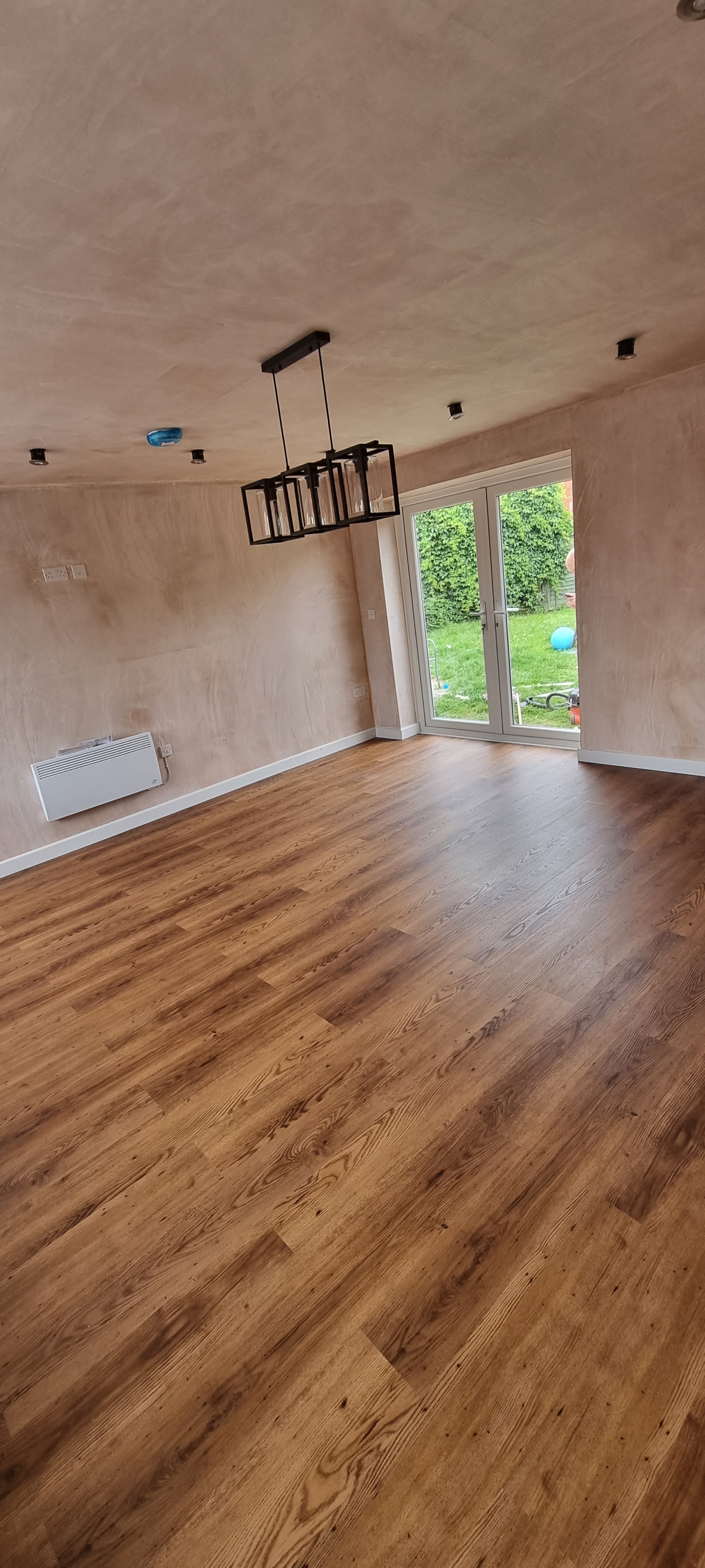 Modern bathroom featuring a walk-in shower, wooden vanity, round mirror, and elegant marble tiles.