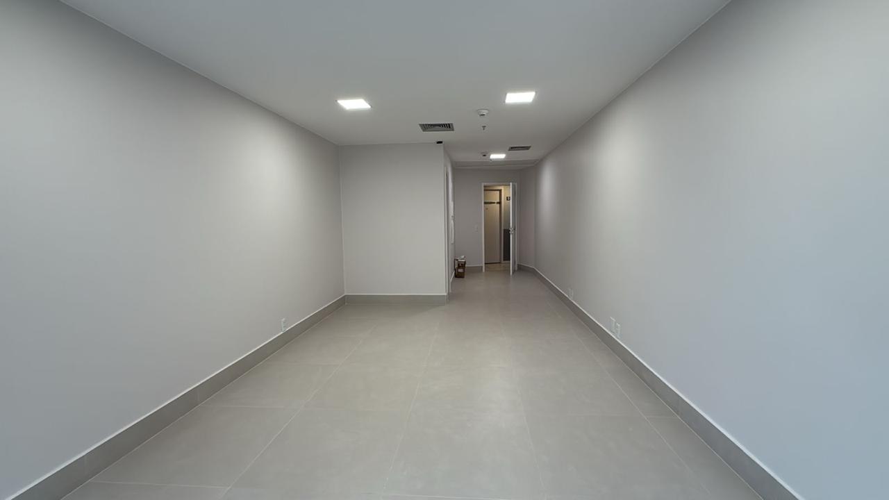 a corner of a room with a chair and paintings