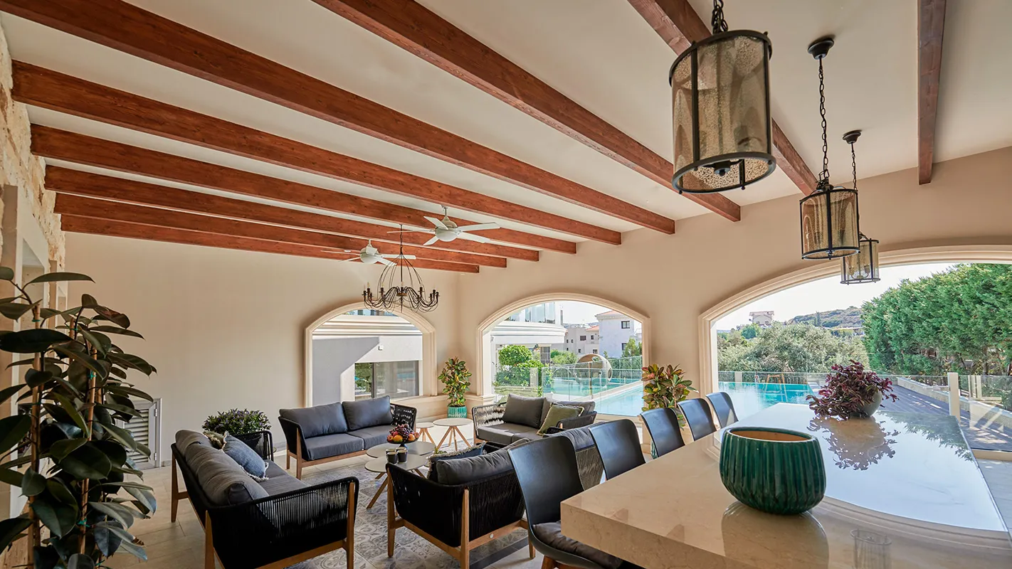 Villa Belmare covered outdoor dining area with timber ceiling beams, pendant lanterns, and poolside seating