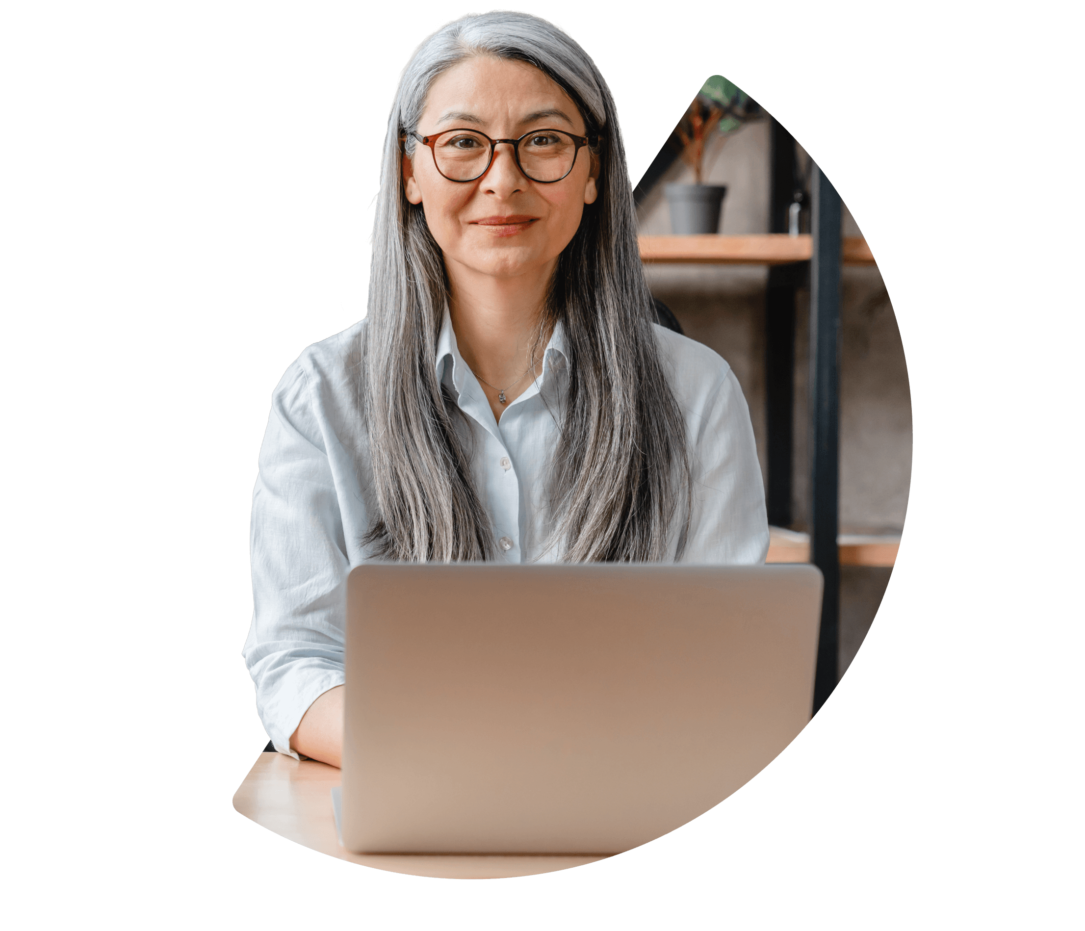 Cropped image of amature lady sitting at a desk looking at the camera.