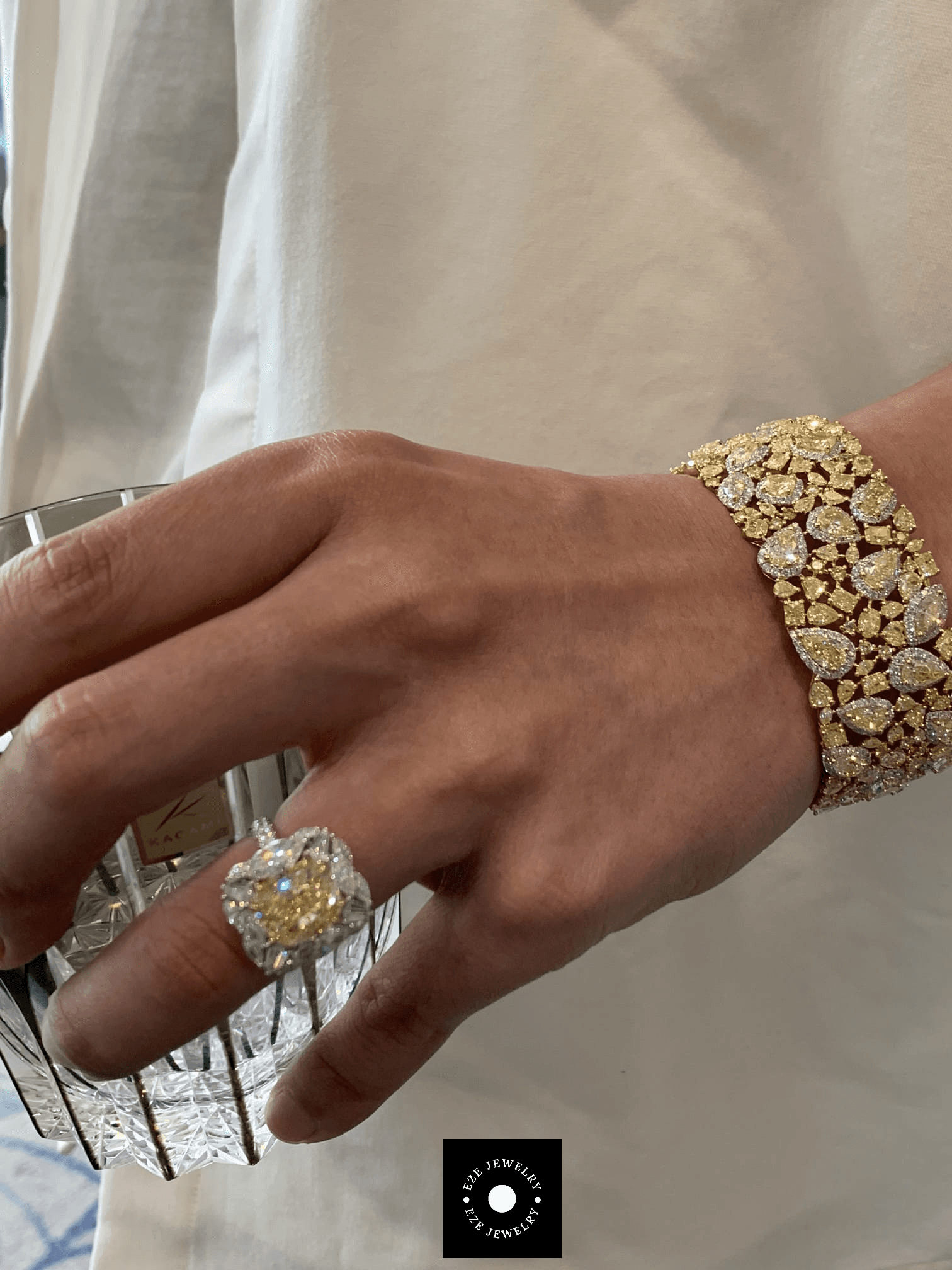 Close-up of natural fancy yellow diamond ring and wide diamond bracelet highlighting craftsmanship and elegant luxury styling.