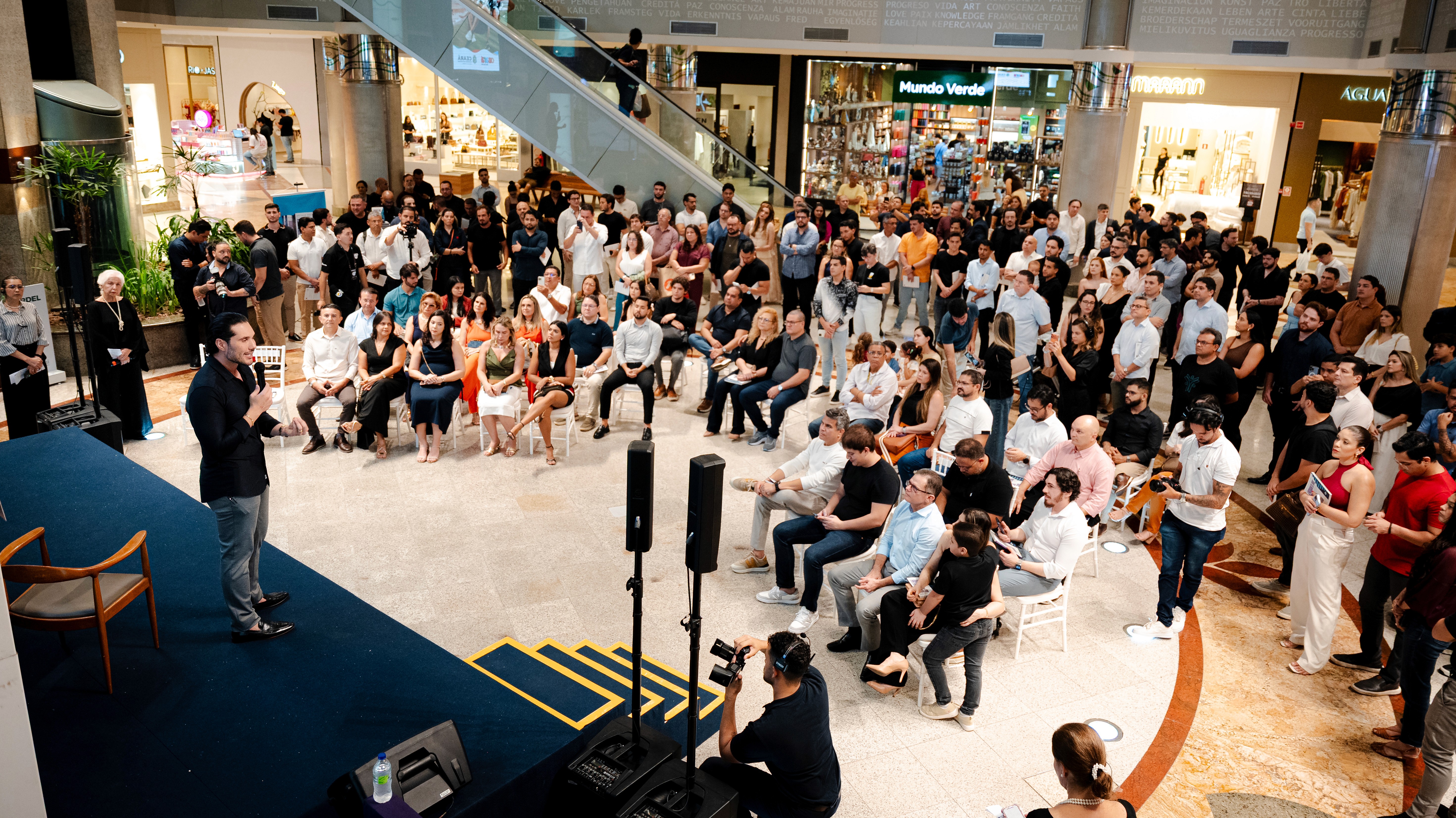 Large crowd enjoying a live concert with stage lights and camera crane filming the event.
