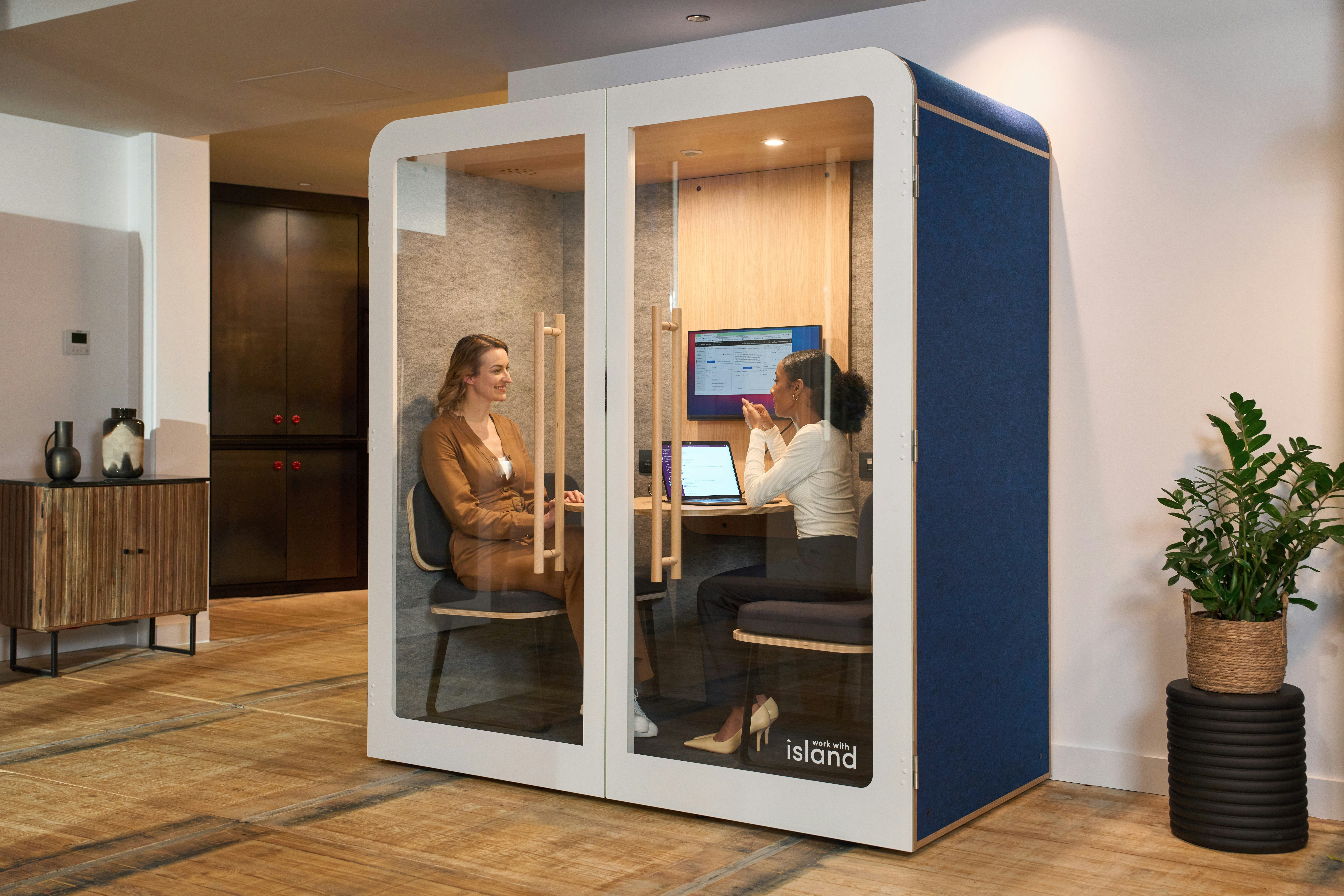A couple of people sitting at a computer in a room