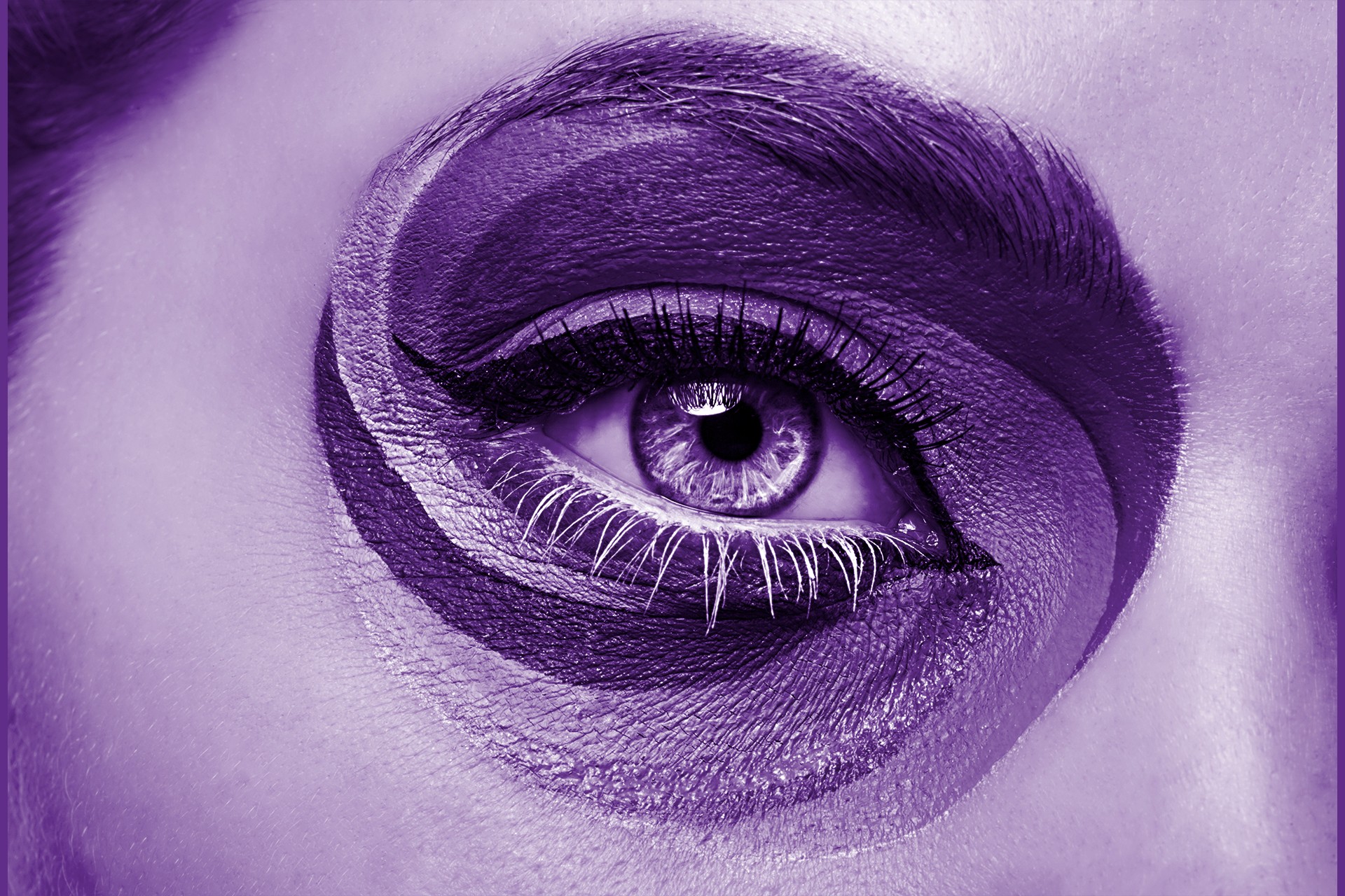 A close up of an eye, with multi-coloured decoration around the eye