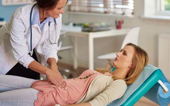 Лікар перевіряє у пацієнтки живіт