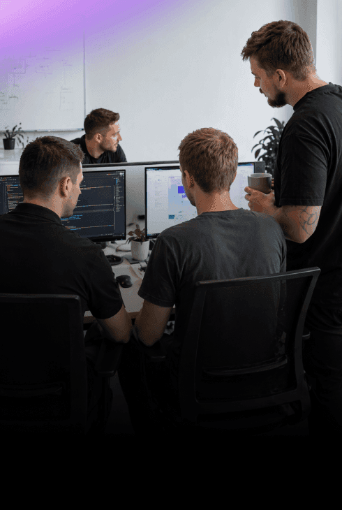 Nextio developers collaborating on custom software development and coding a web application on dual monitors.