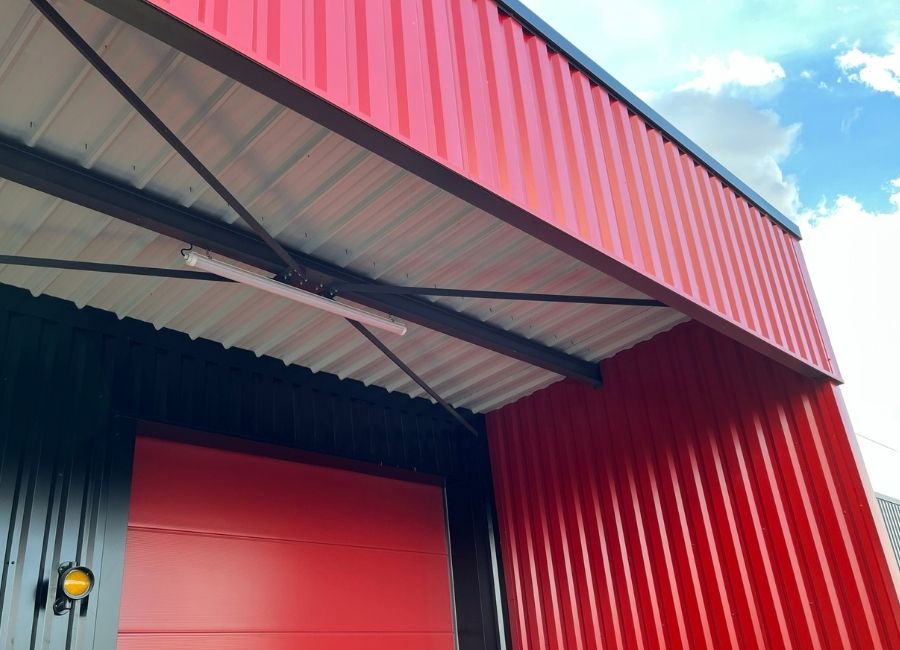 Détail de toiture en bac acier rouge d’un bâtiment industriel.