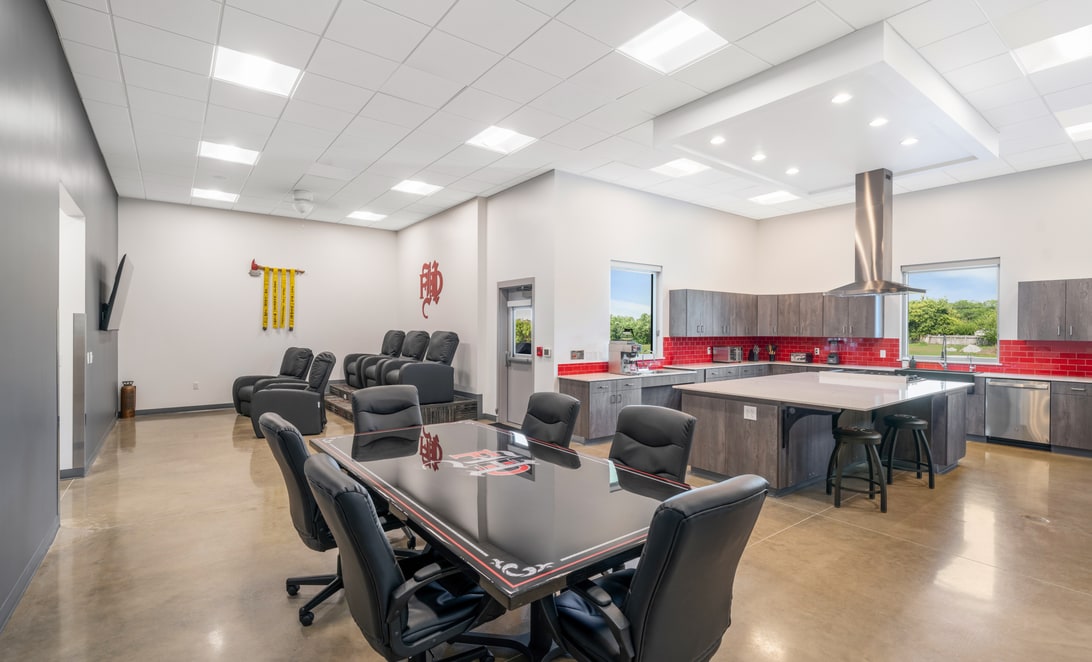 Dining and training room with long tables and clerestory windows at Hewitt Fire Station 2, by Martinez Architects