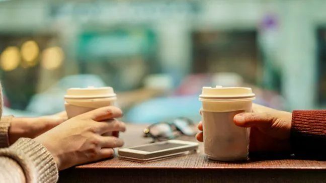 Two people drinking coffee at a coffee store