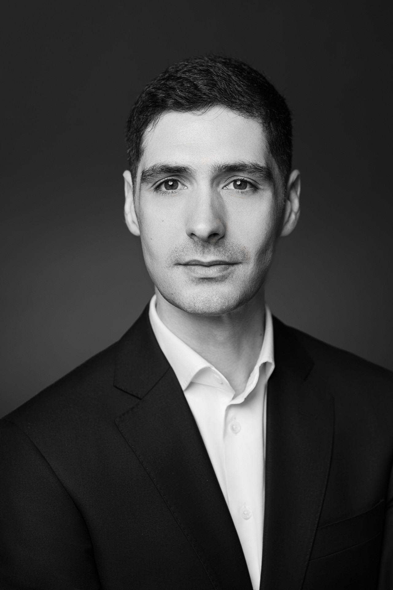 Schwarzweisses LinkedIn Headshot eines Mannes im Anzug mit direktem Blick, professionelles Business Portrait aus Zürich