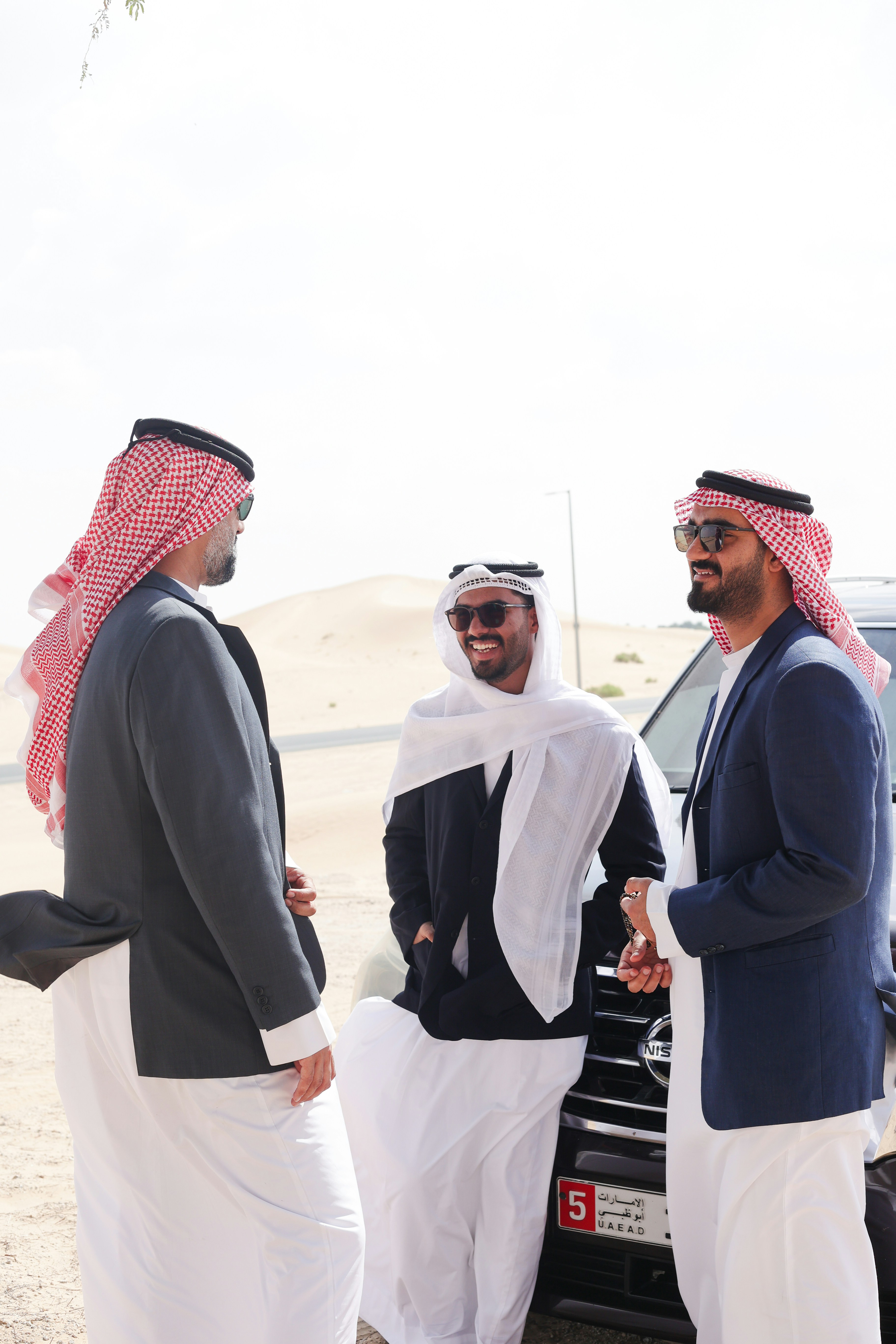 A group of men standing next to a car