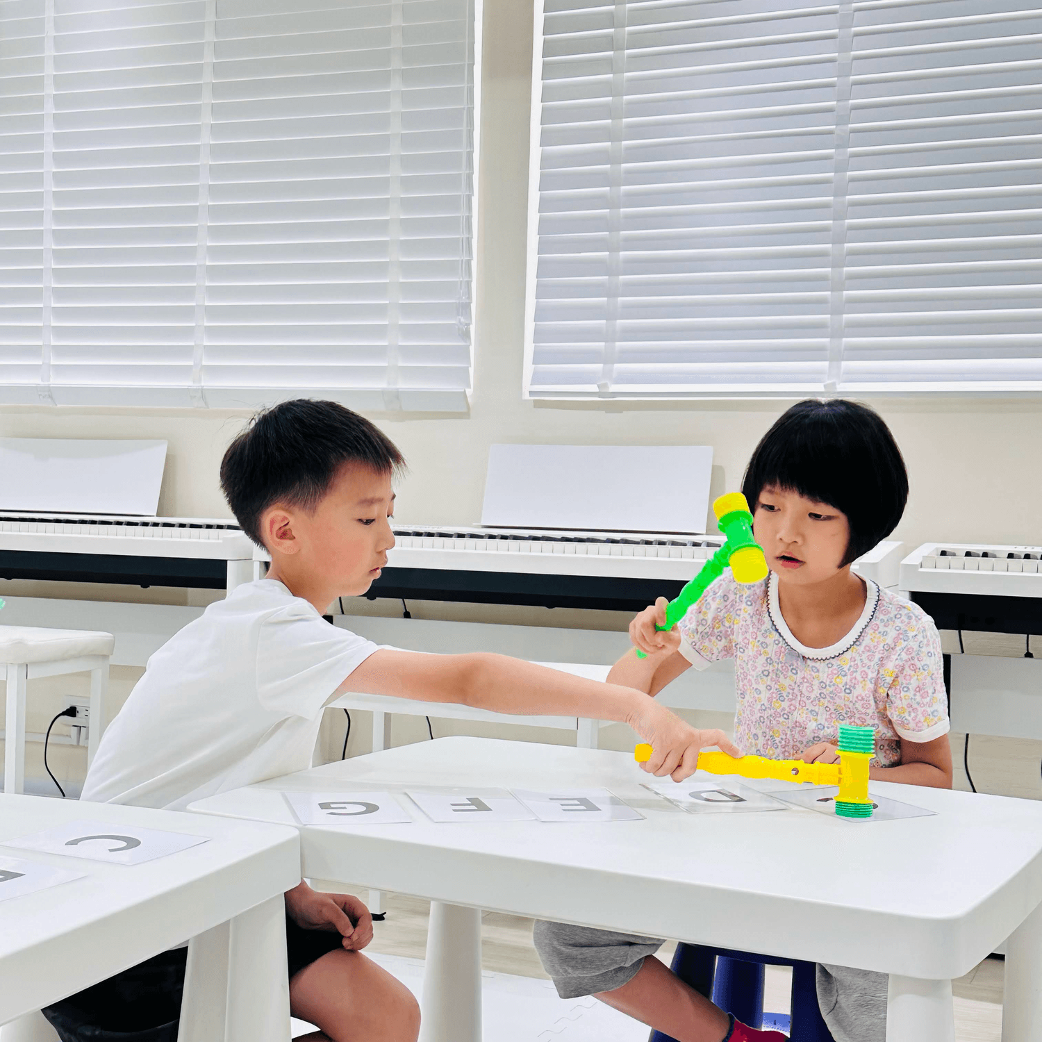 Studio portrait of a young person with blond hair, wrapped in translucent orange fabric against a blue background