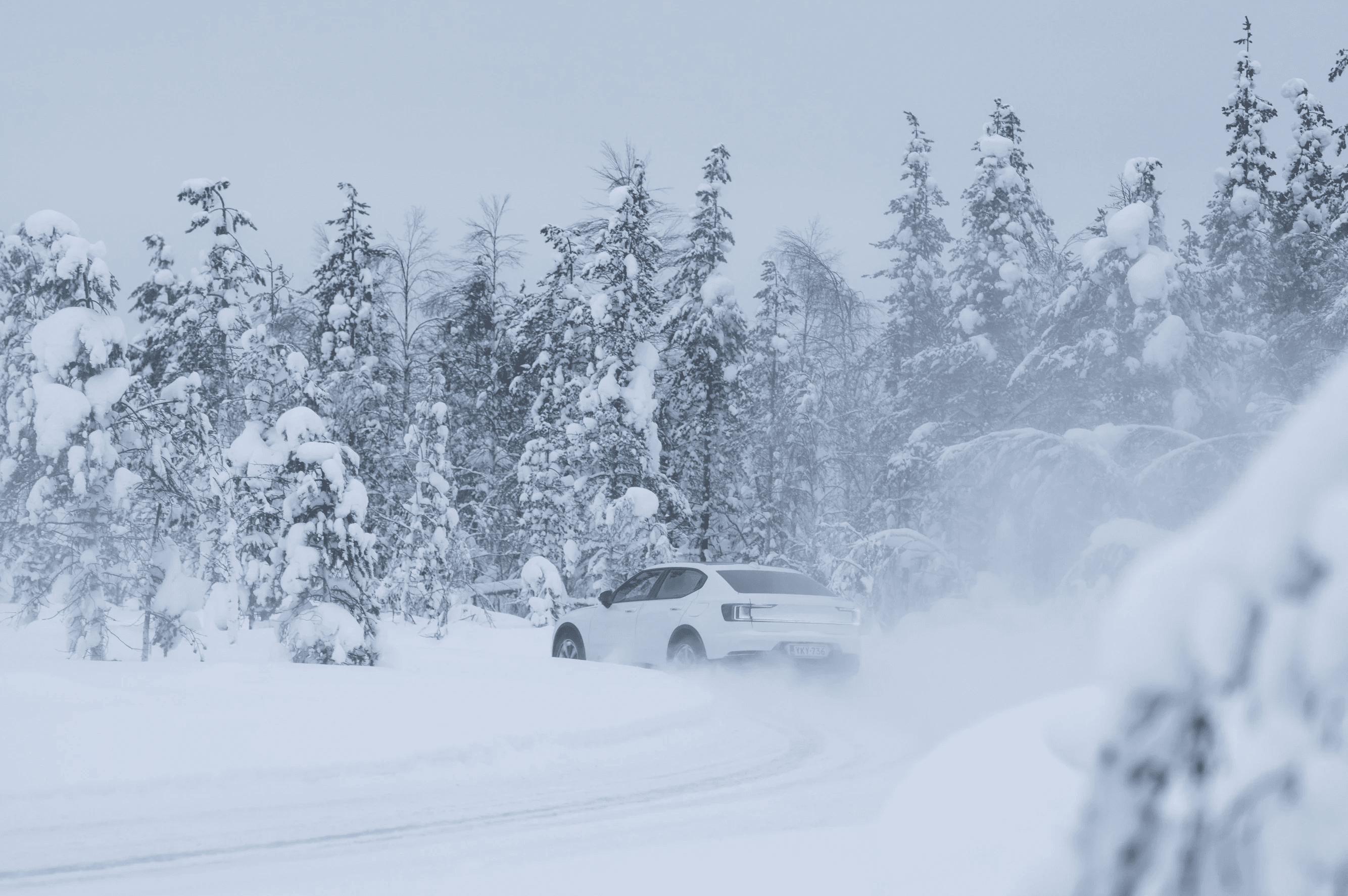 Vue arrière d'une Polestar 2 sur une route enneigée en hiver avec pompe à chaleur