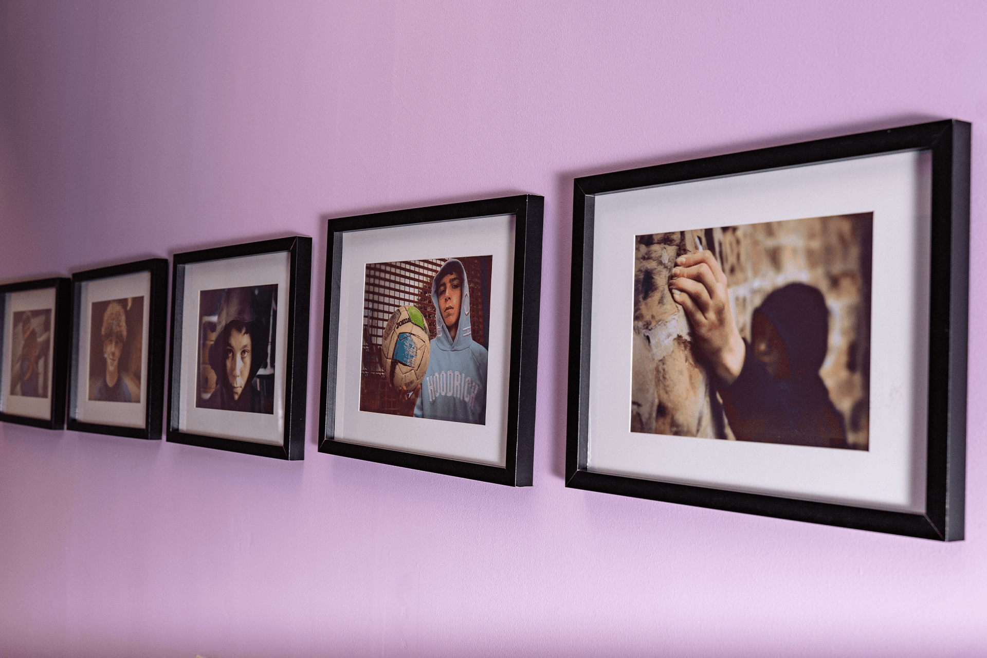 Wall adorned with frames displaying photos of students to celebrate their time at the institution