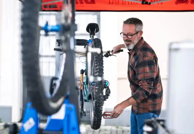 Mécanicien vélo effectuant une révision complète sur un marché du Calvados