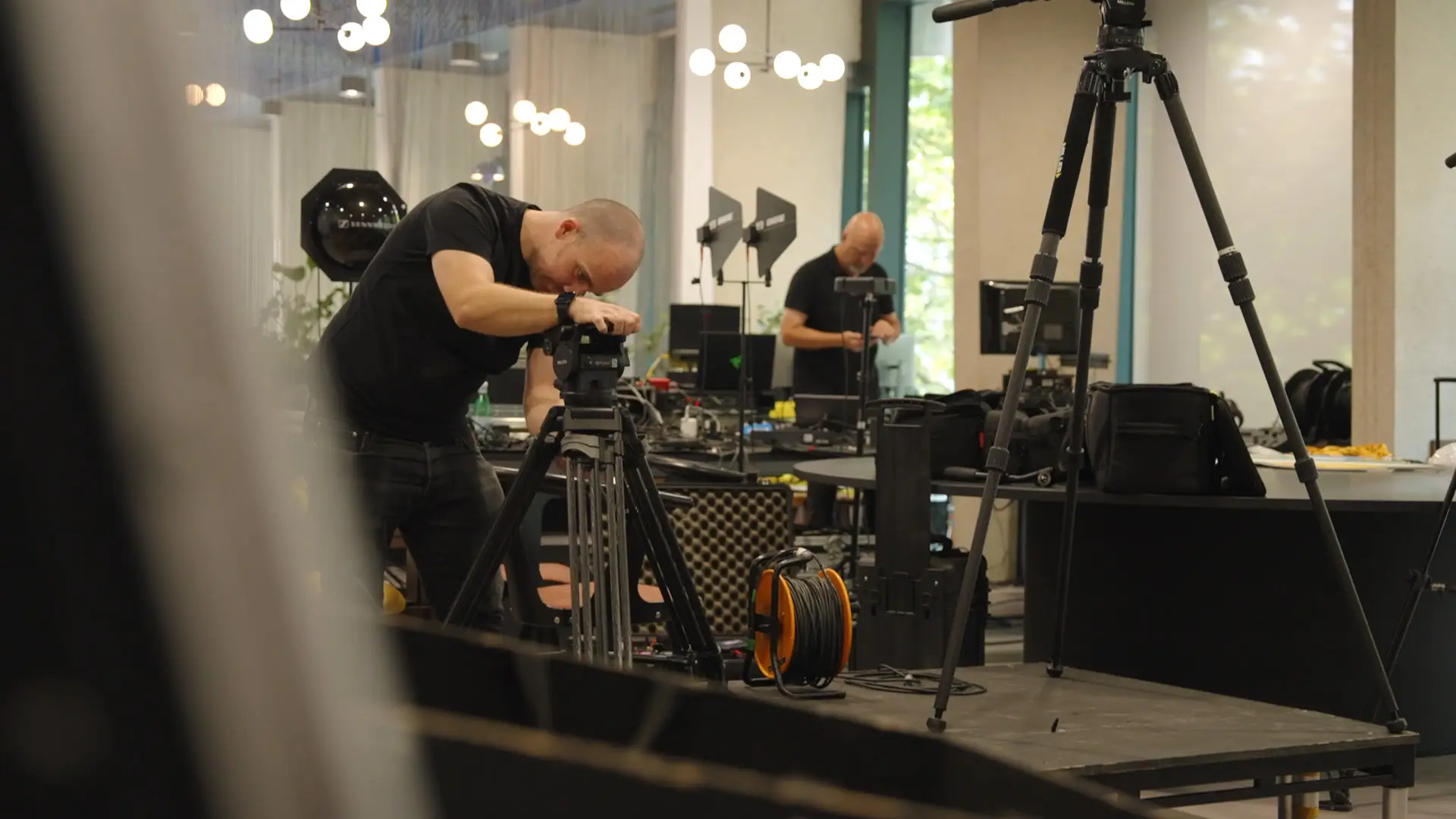 Camera operator preparing filming equipment during setup for the Kantar AI Festival.