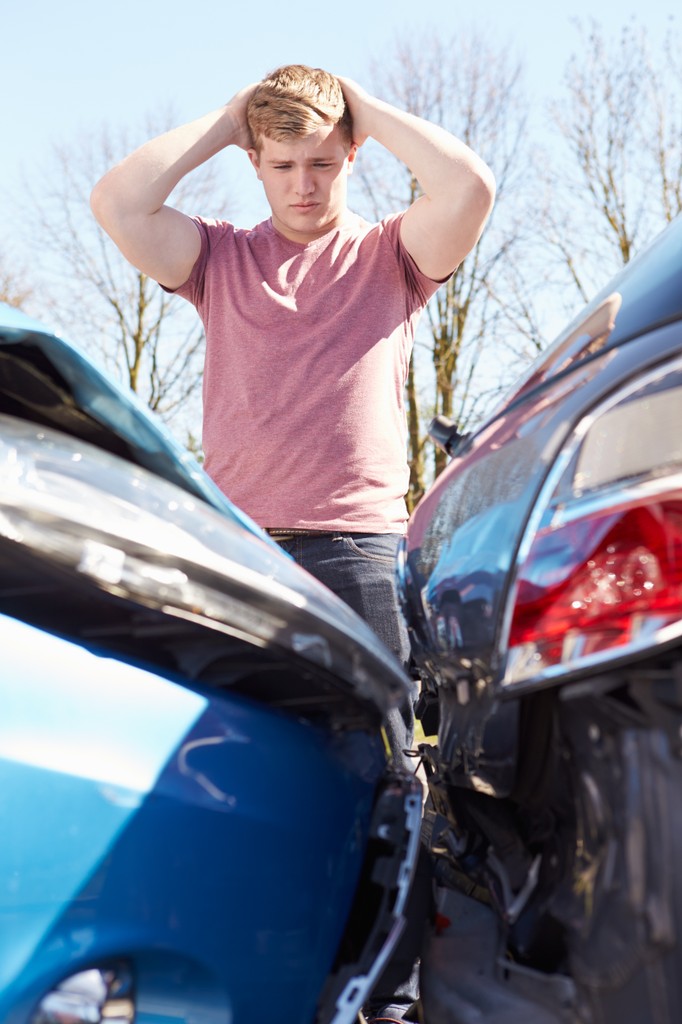 man at scene of car accident looking stressed