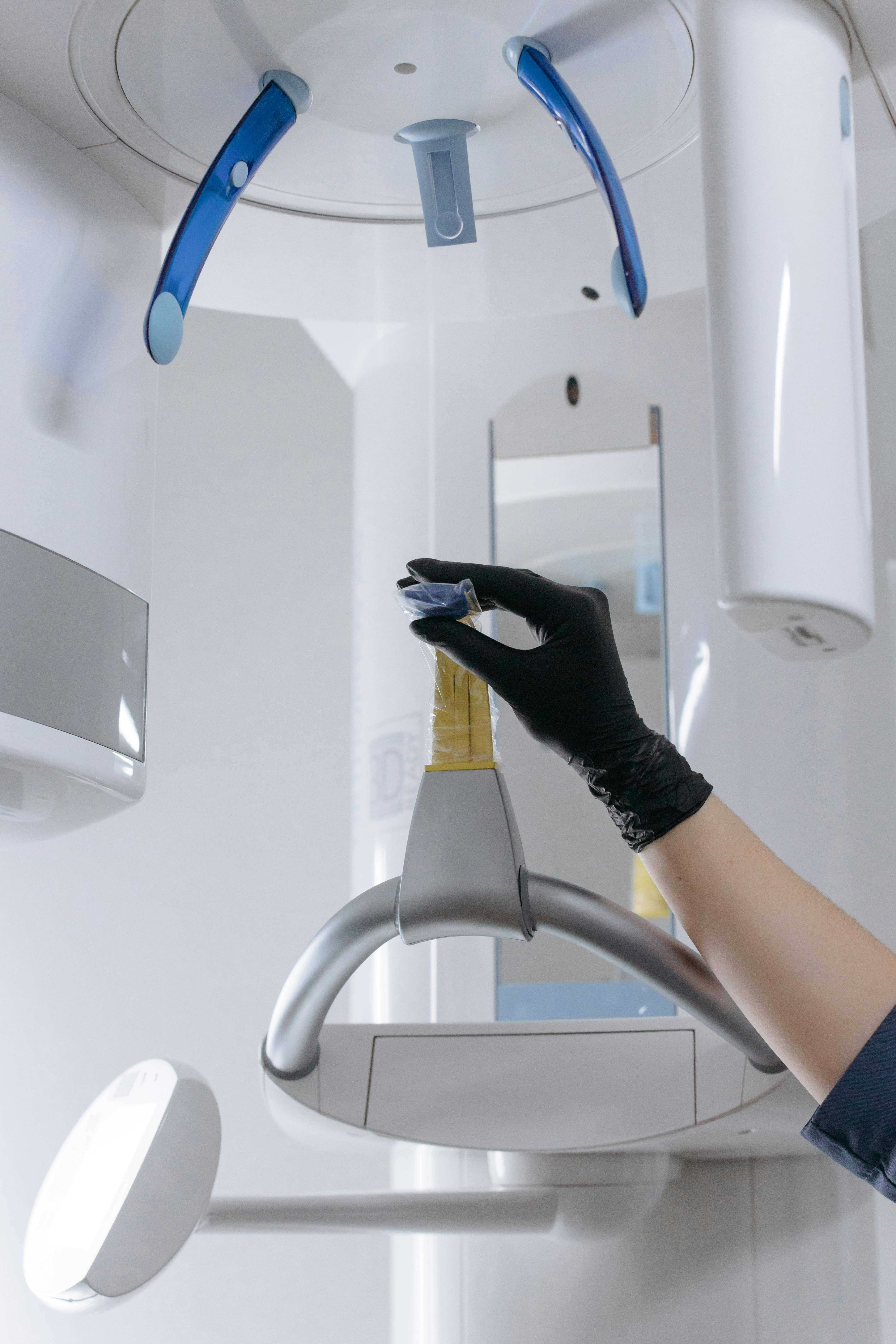 A picture of Technician adjusting dental 3D X-ray or CBCT imaging machine.
