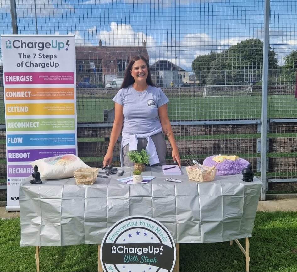 Steph standing behind a table with items she uses during a session