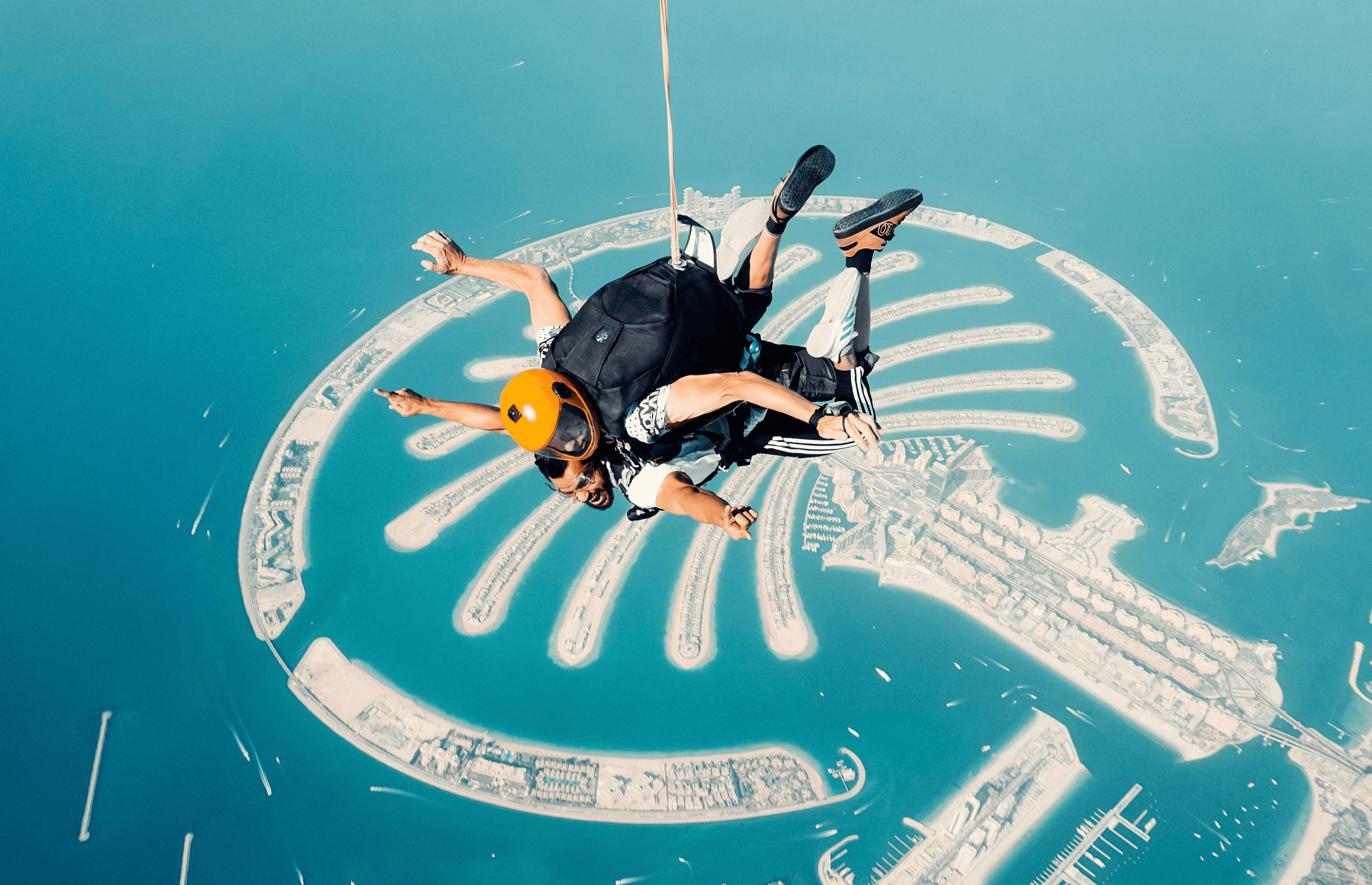 a man flying through the air while riding a parachute