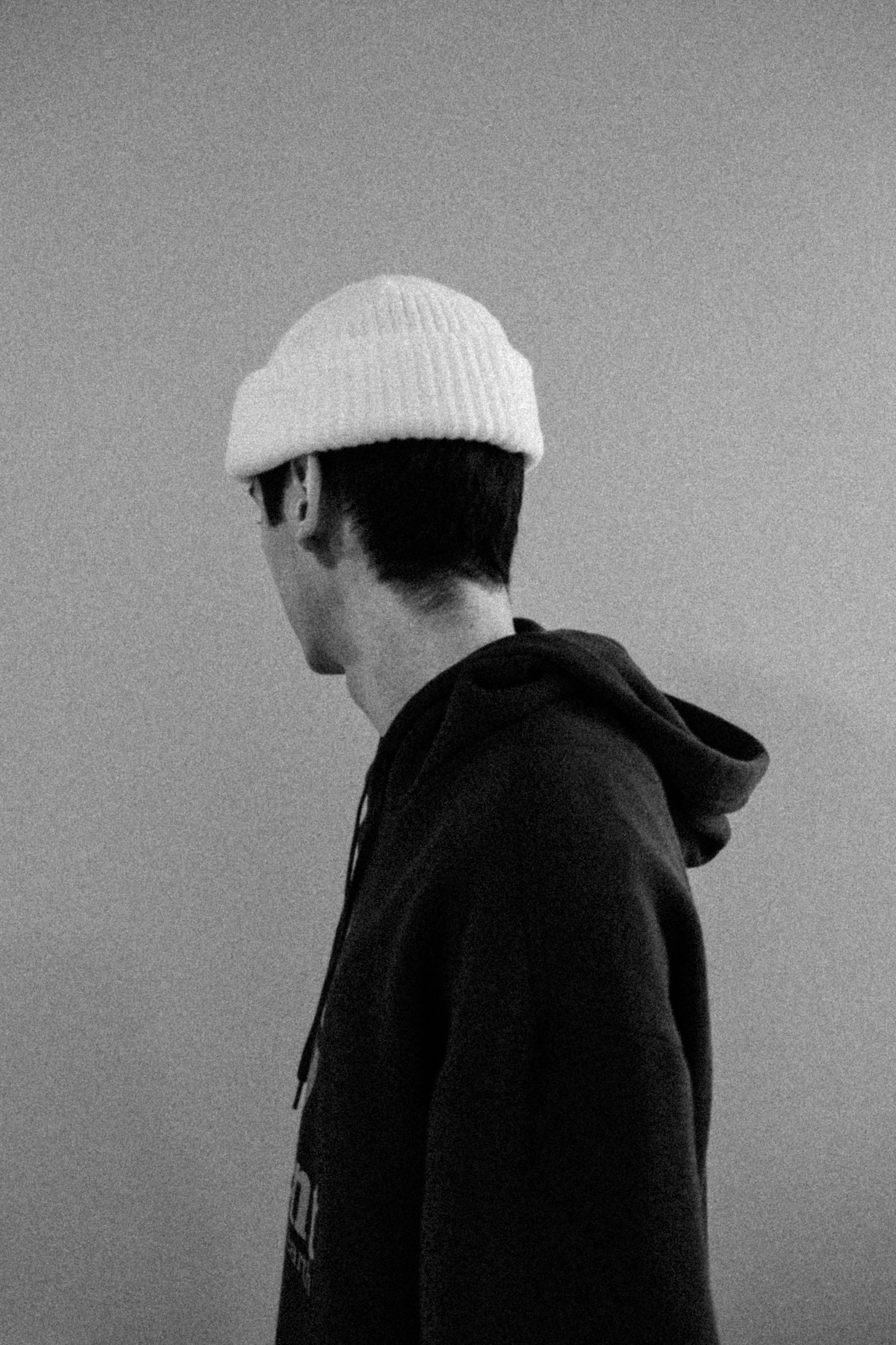 male model with his back turned to camera in street clothing