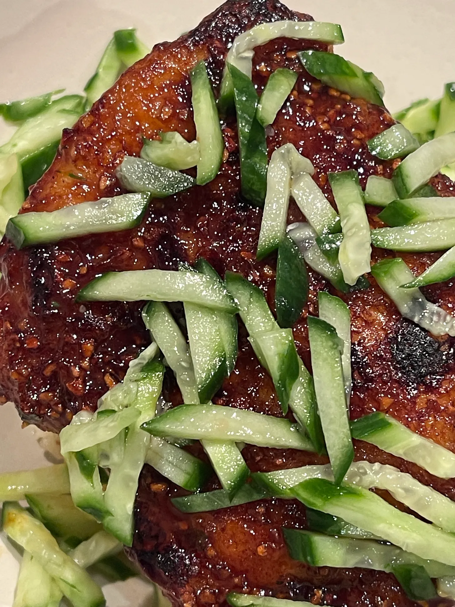 Golden-brown chicken thighs with sliced cucumber