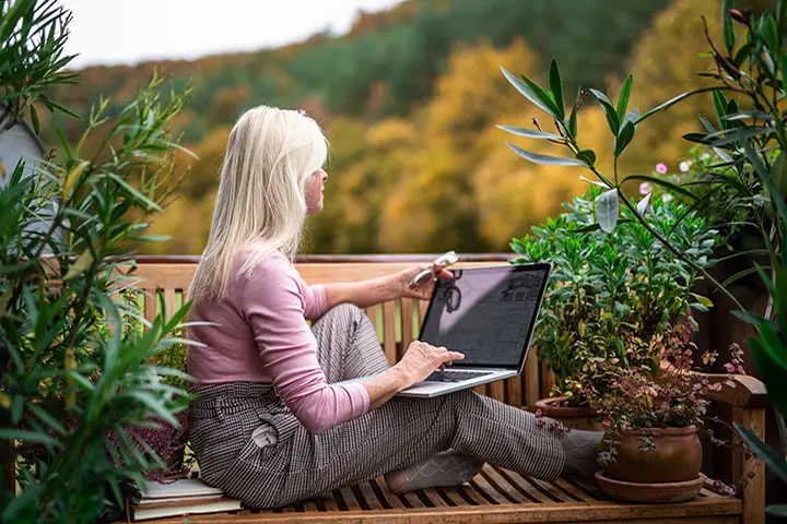 Frau im Garten mit Laptop