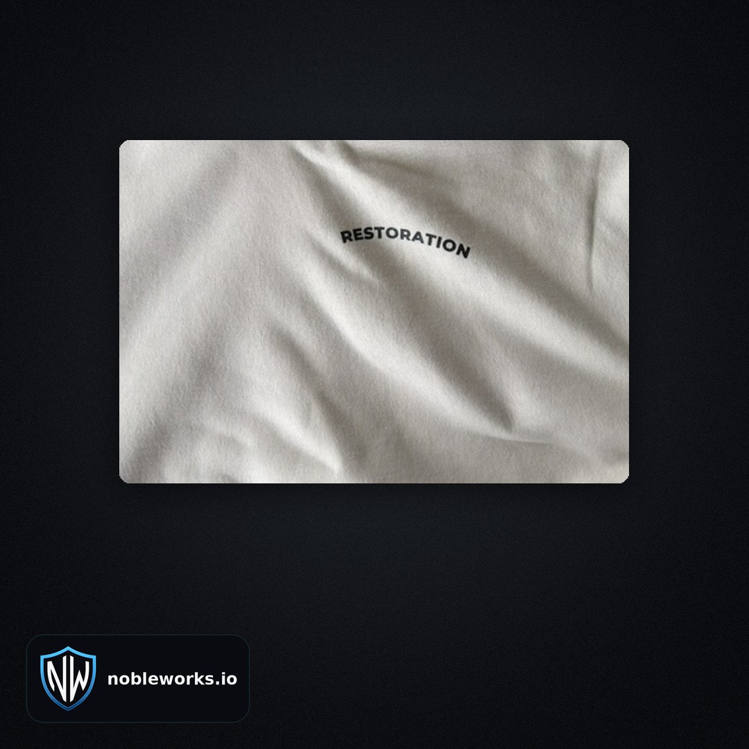 Close-up of the arched RESTORATION wordmark screen printed in black on a Soft Beige hoodie