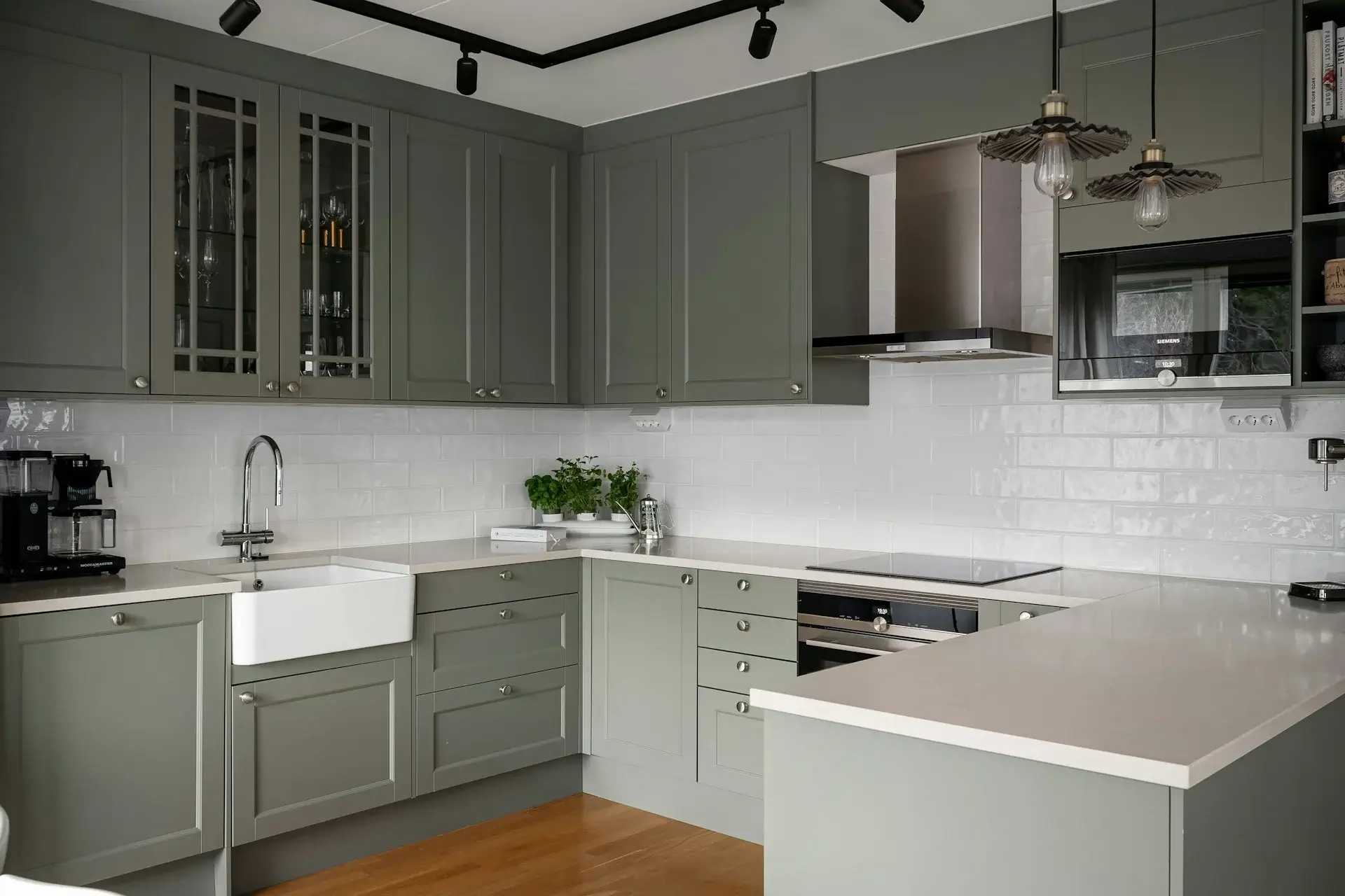Modern gray kitchen with shaker cabinets, white tile backsplash, and island countertop.