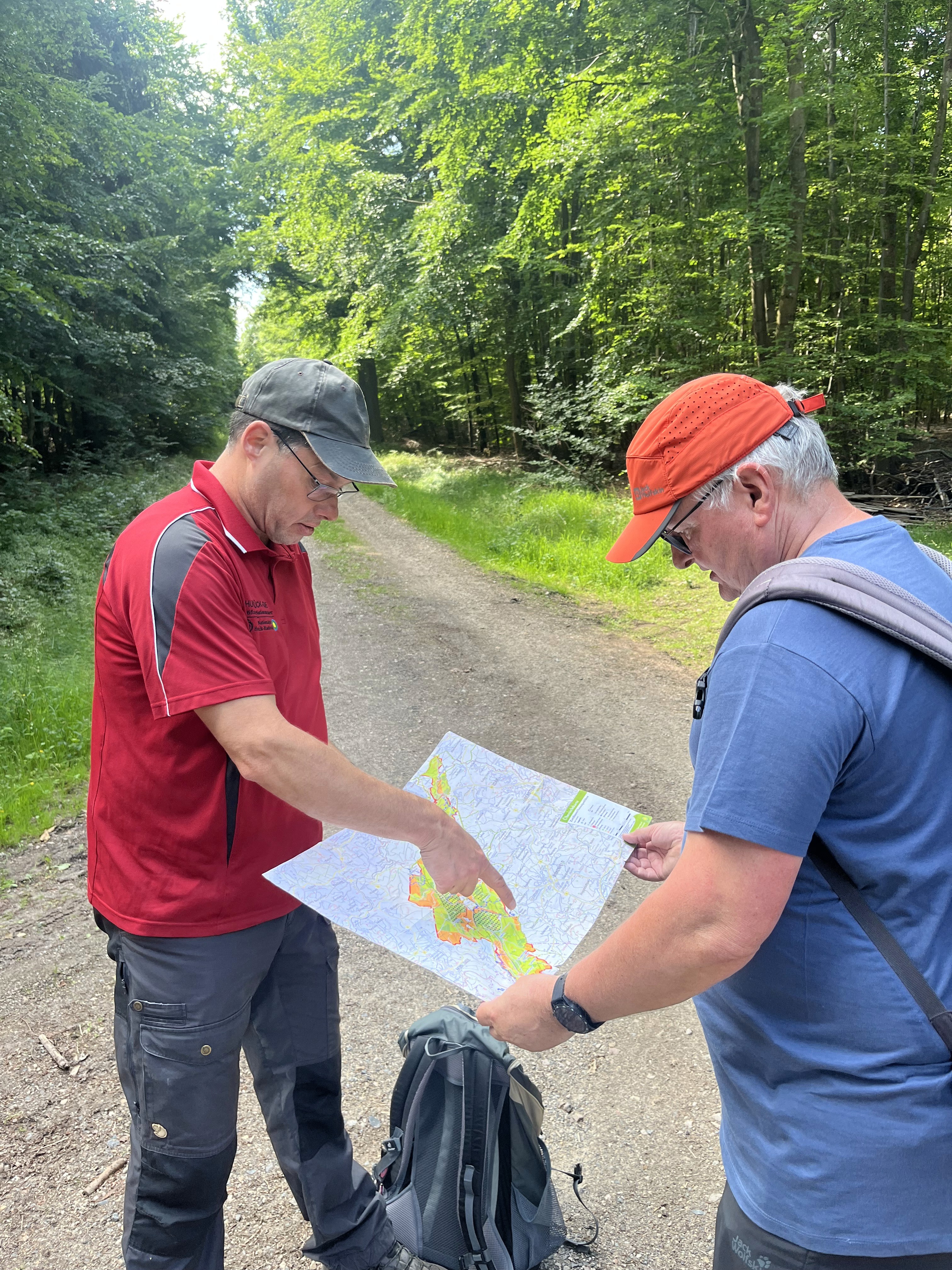 Nationalpark Führer Sascha erklärt mit einer Karte die Pflegezonen des Nationalparks