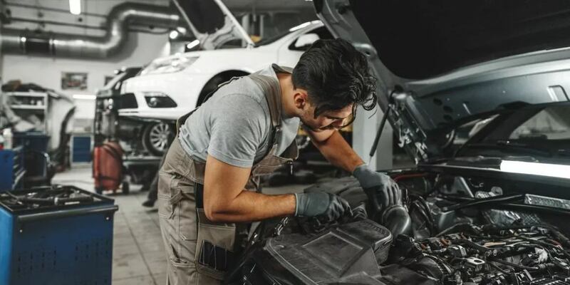 hombre arreglando el motor de un auto