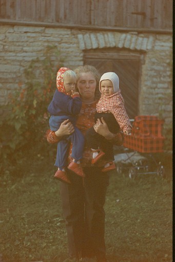 Naine kahe väikese lapsega süles