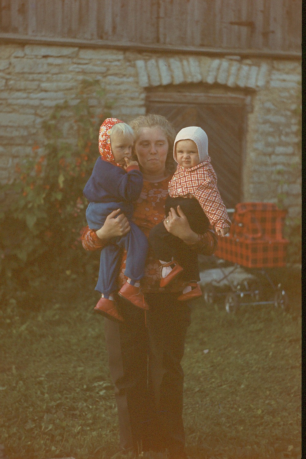 Naine kahe väikese lapsega süles