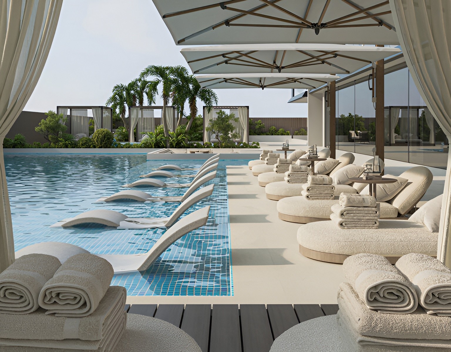 The pool area at Belle Vie by Zimaya, showcasing lounge chairs and umbrellas for guests to enjoy.