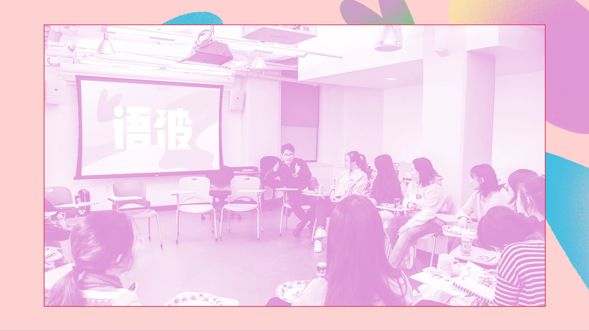 A group of people sits in a room facing a large projection screen displaying text in Chinese characters. The room has white walls, exposed ceiling fixtures, and several tables with chairs. A woman in a dark top is seated near the screen, appearing to present or speak to the group. The image has a pink border and features pastel-colored abstract shapes in the corners.