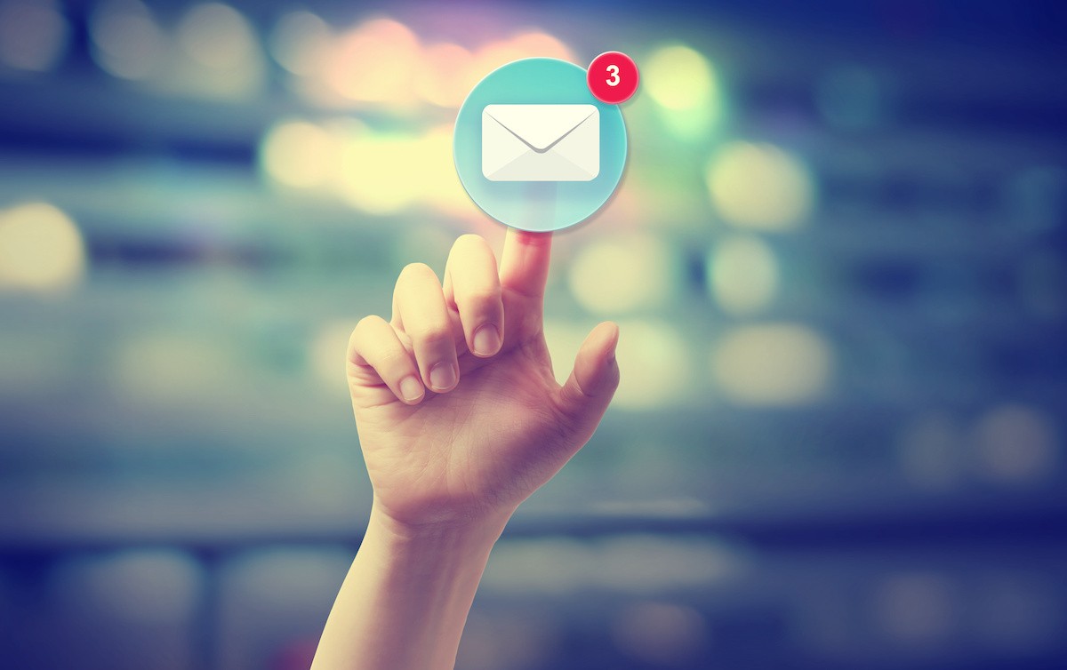 Hand pressing an email icon