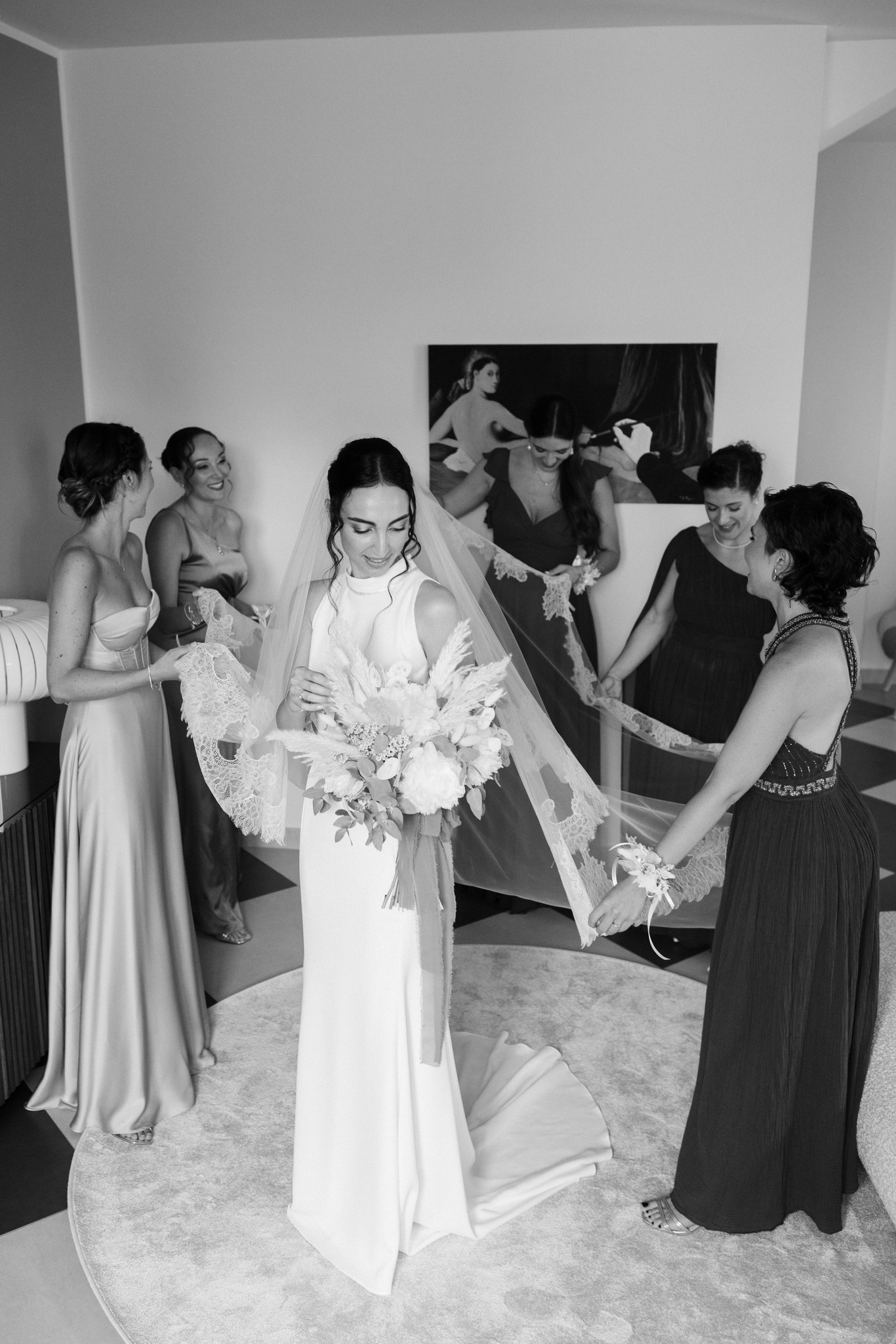 Sposa in abito bianco circondata da amiche che sistemano il velo, preparativi matrimonio a Parco di Montebello