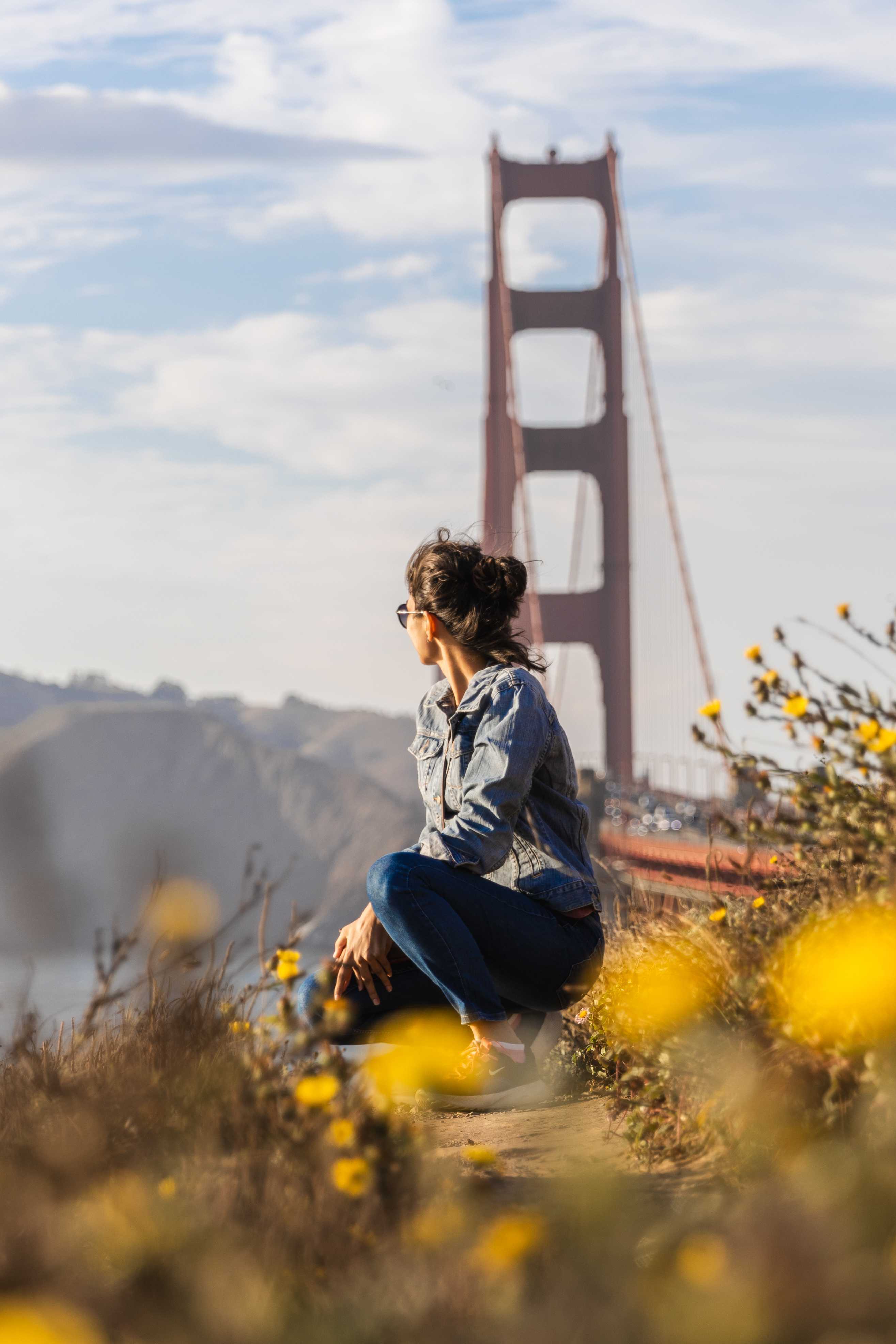 A thoughtful young person with dark hair gazes to the side, captured in soft black and white lighting.