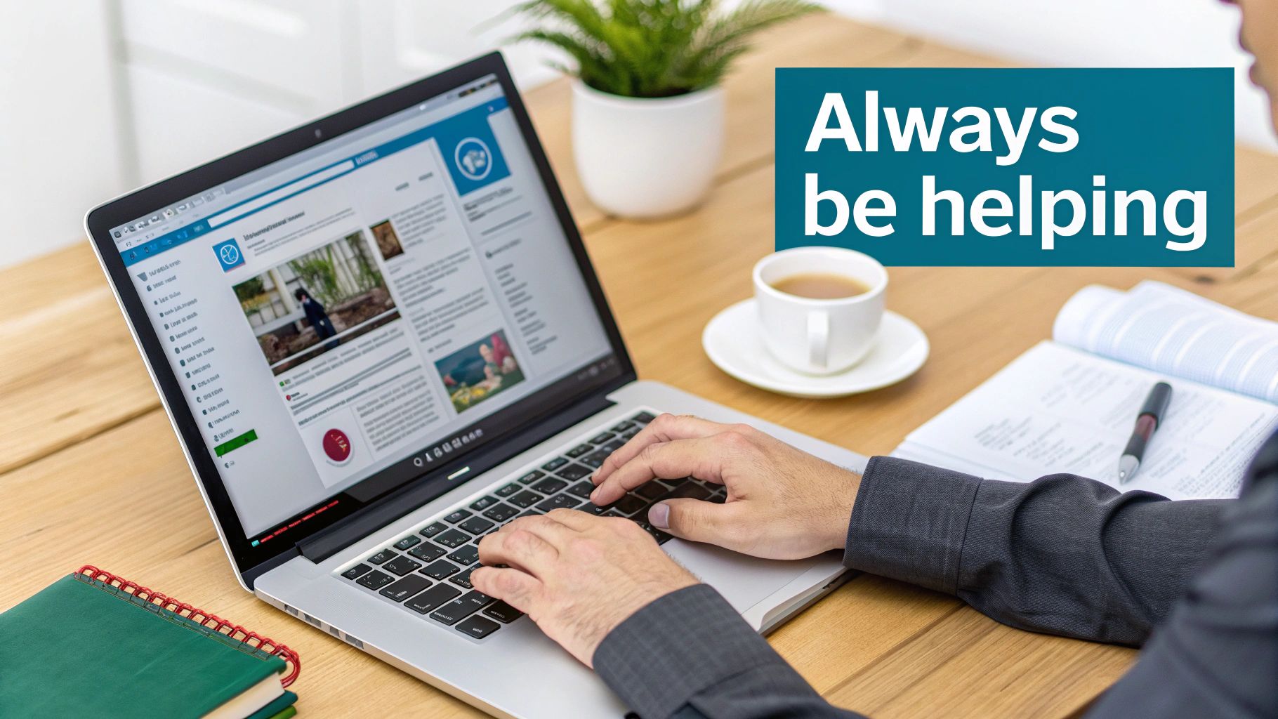 A person's hands typing on a laptop displaying a website feed, a coffee cup, and a notebook on a wooden desk.