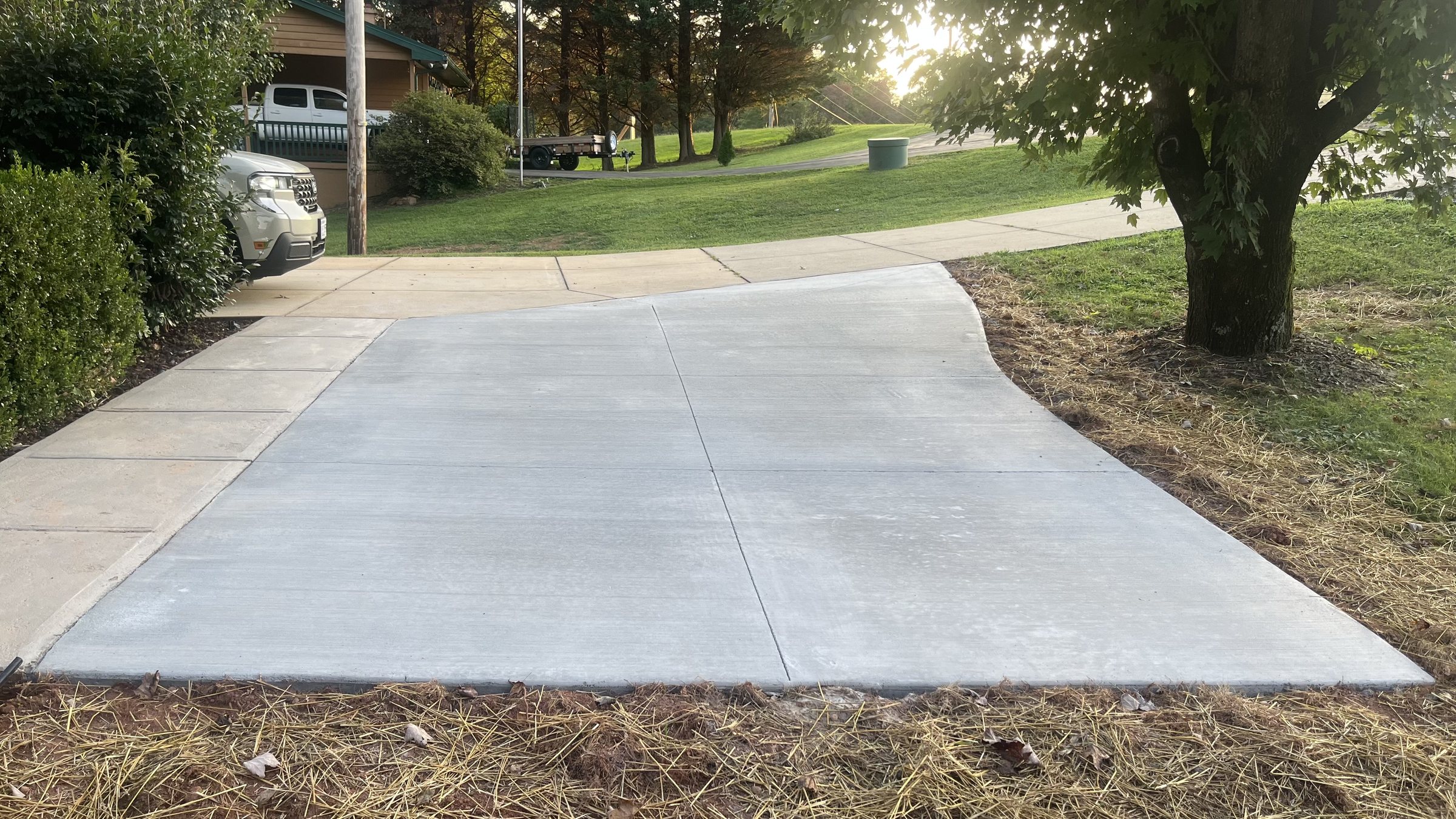 New concrete driveway apron poured to meet the existing sidewalk, broom finished with control joints