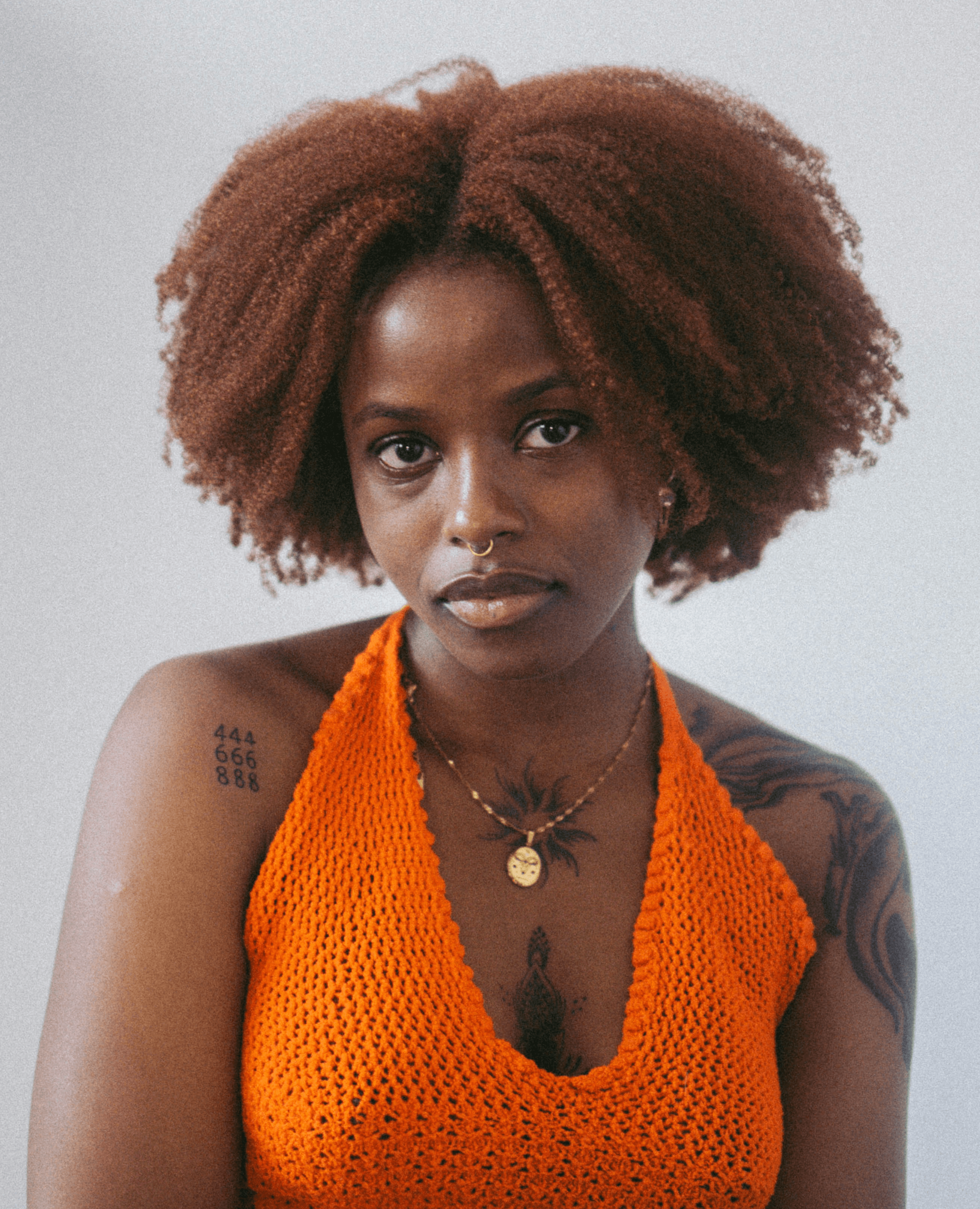 a woman with red hair wearing an orange top