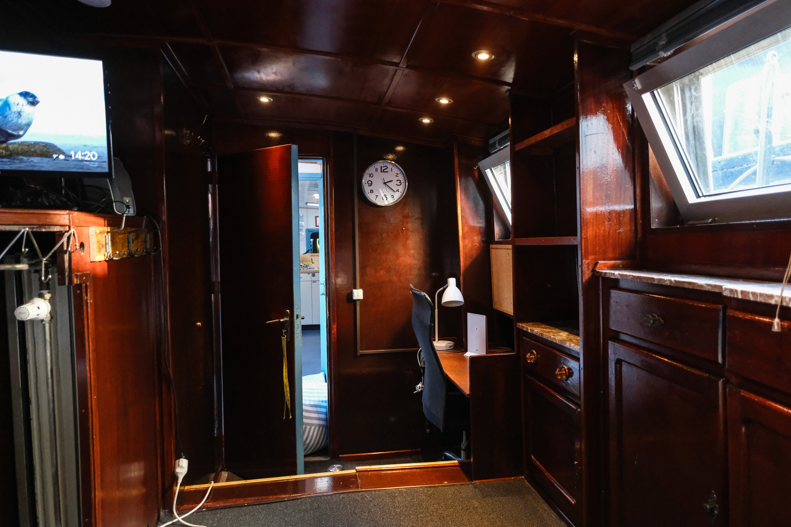 Beige upholstered bed with patterned pillows and ottomans