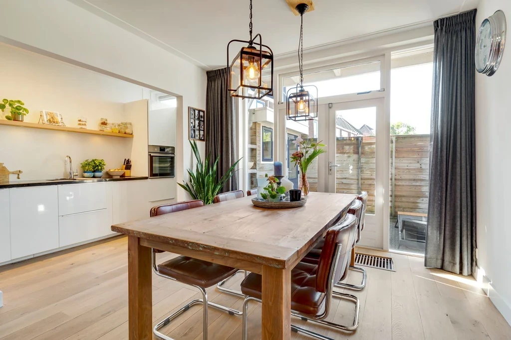 Kitchen and dining space with a wooden table and pendant lights