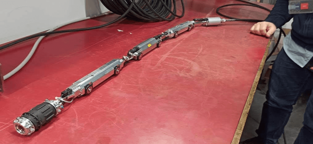 Multi-segment DA_TLR inspection robot train with tether, laid out on the workbench