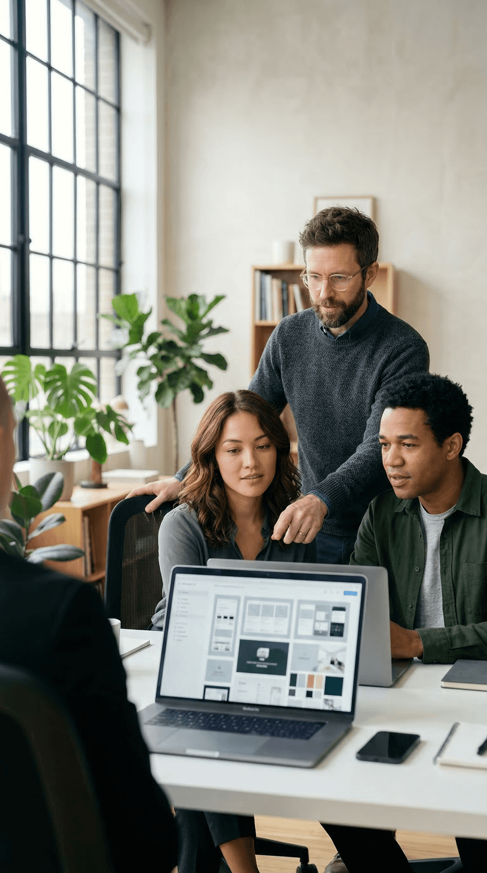 Team reviewing design work together on a laptop
