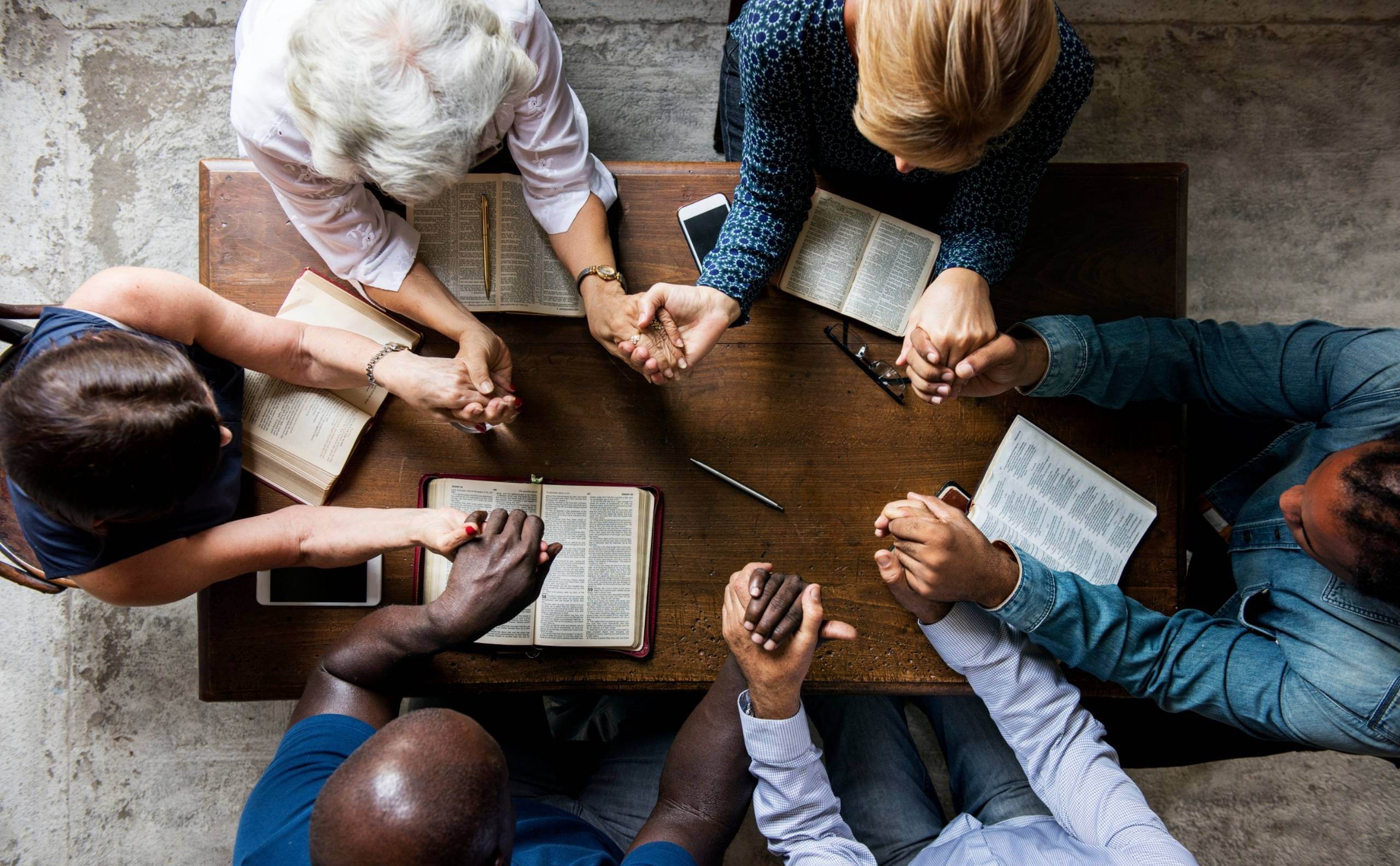 people praying around a table