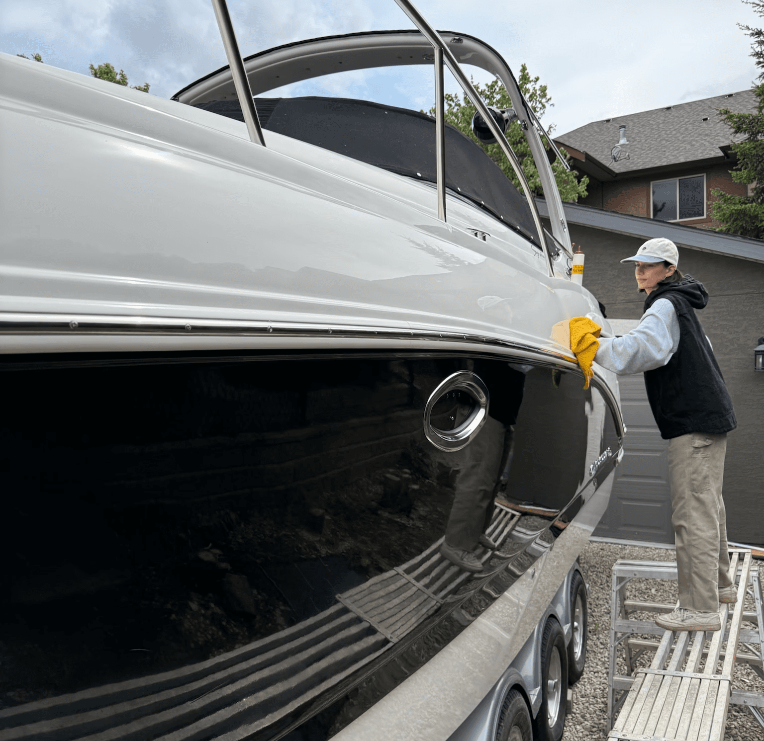 A woman polishing the side of a large boat