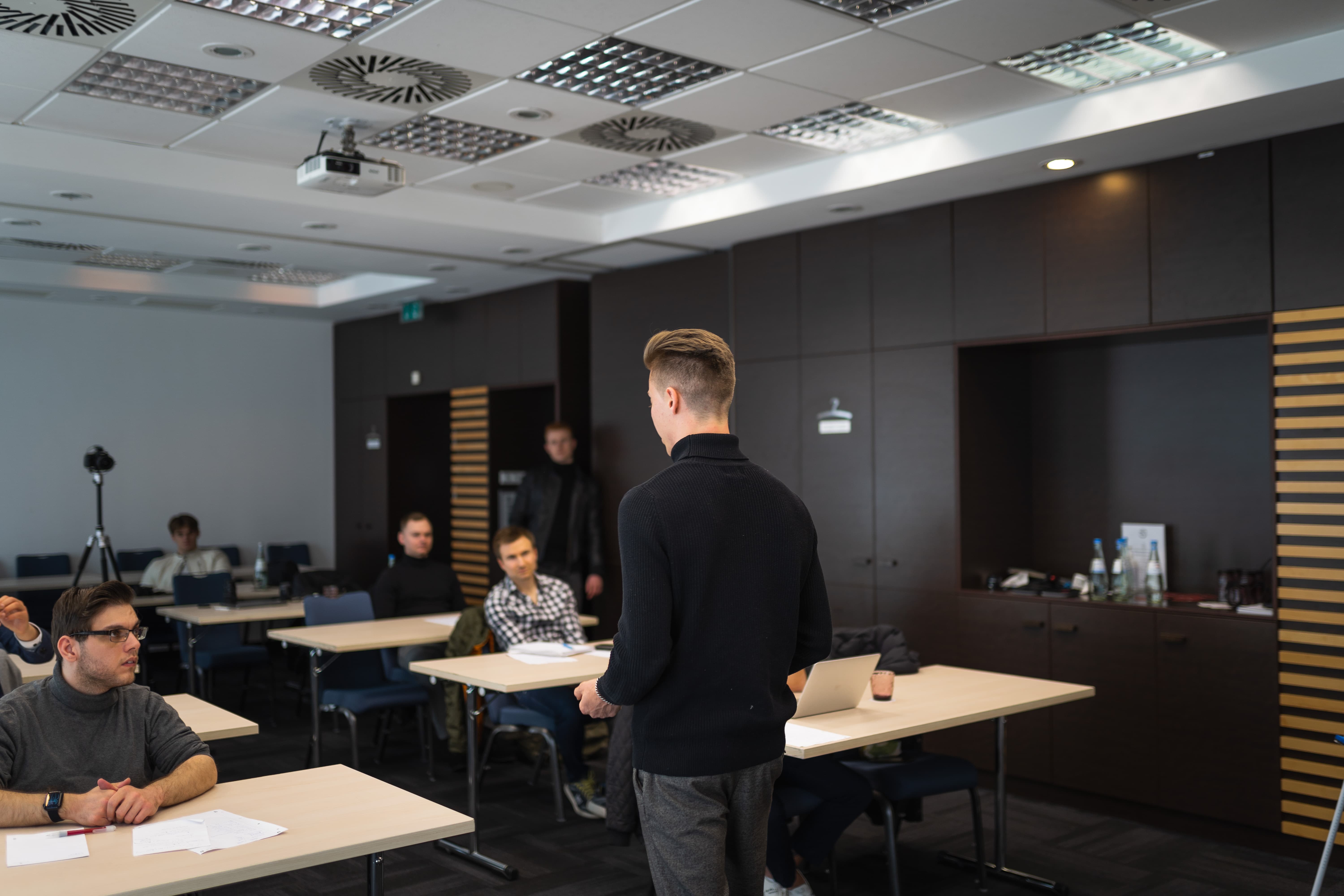 eine person präsentiert etwas in einem raum mit ein paar leuten