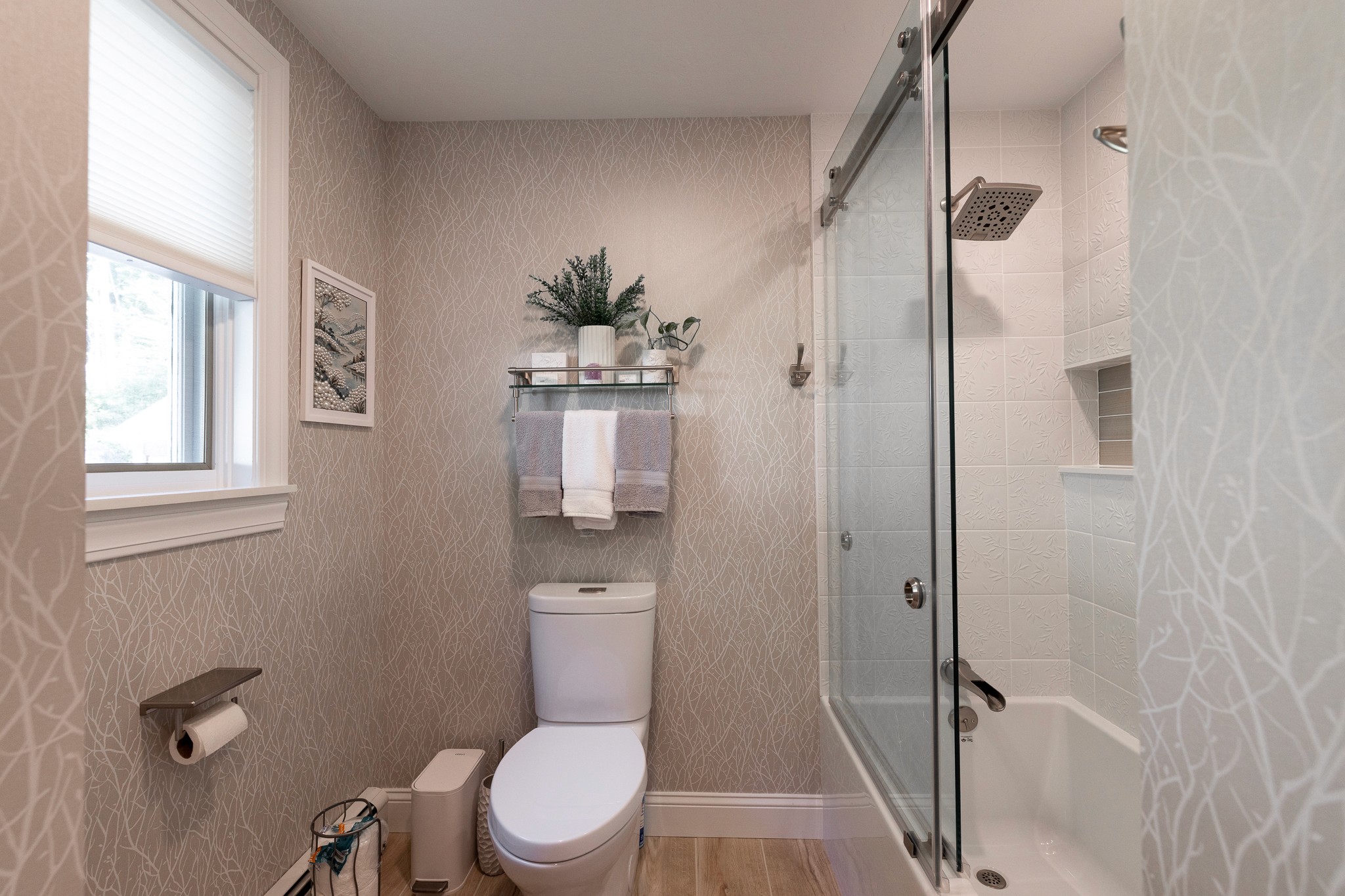 remodeled bathroom with wallpaper and silver fixtures